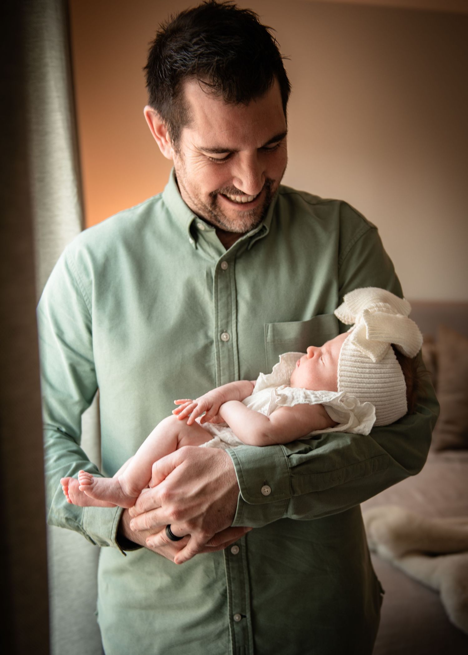 Parent in mint green shirt holding and bonding with newborn baby.
