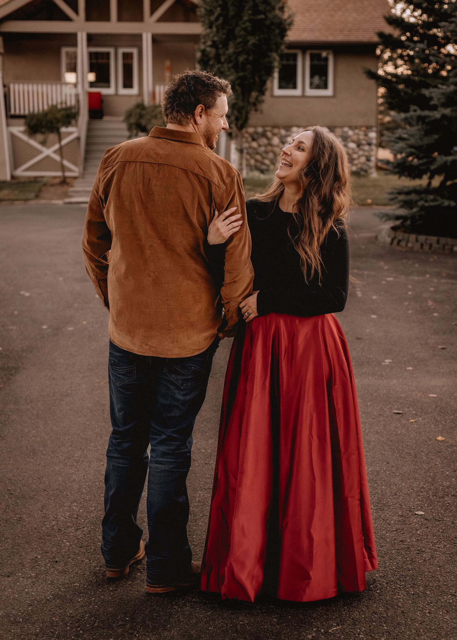 A couple walks together on a paved path wearing coordinated fall outfits.