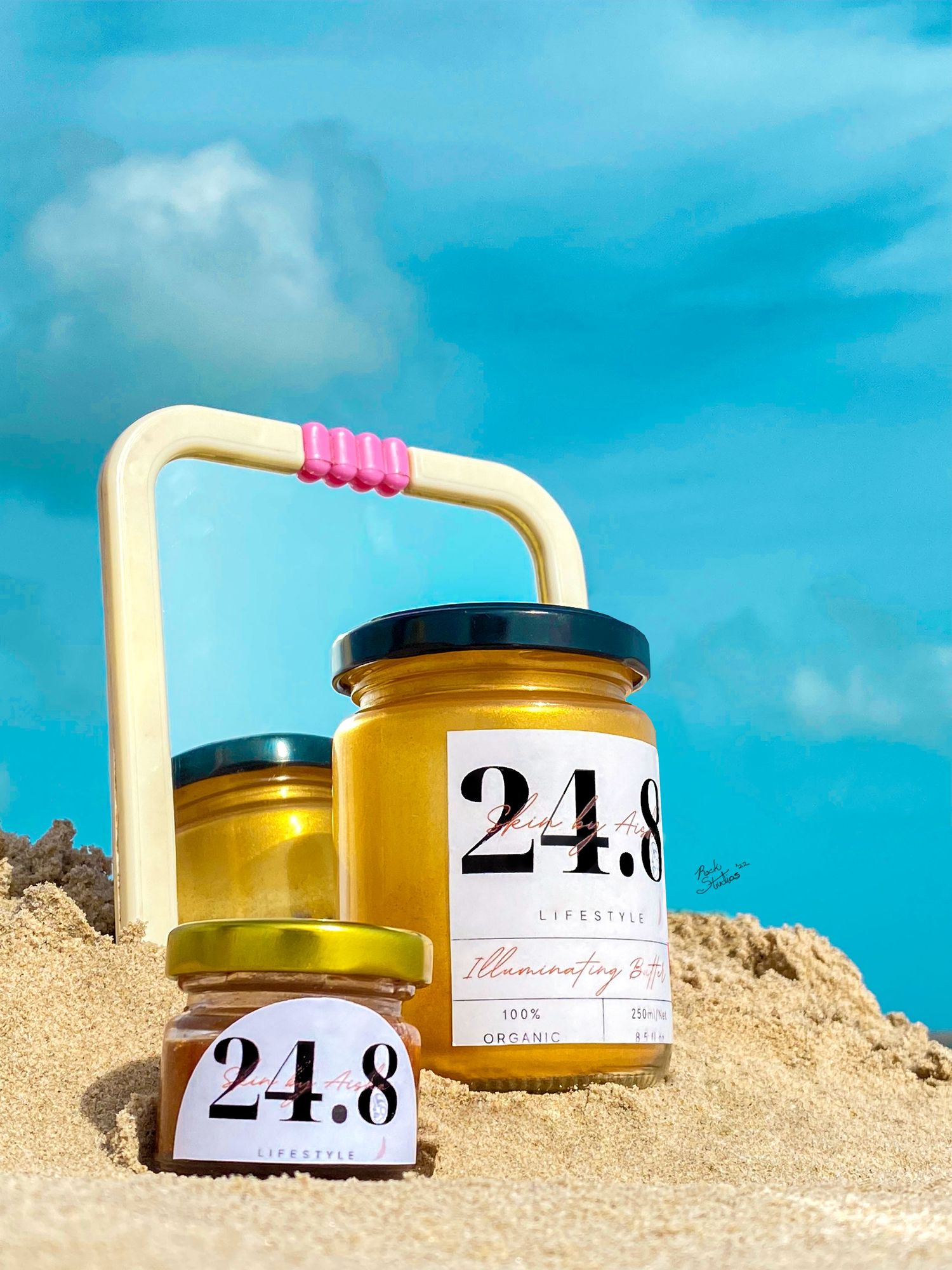 Editorial product shoot of 24.8 body scrub and lip balm on beach sand