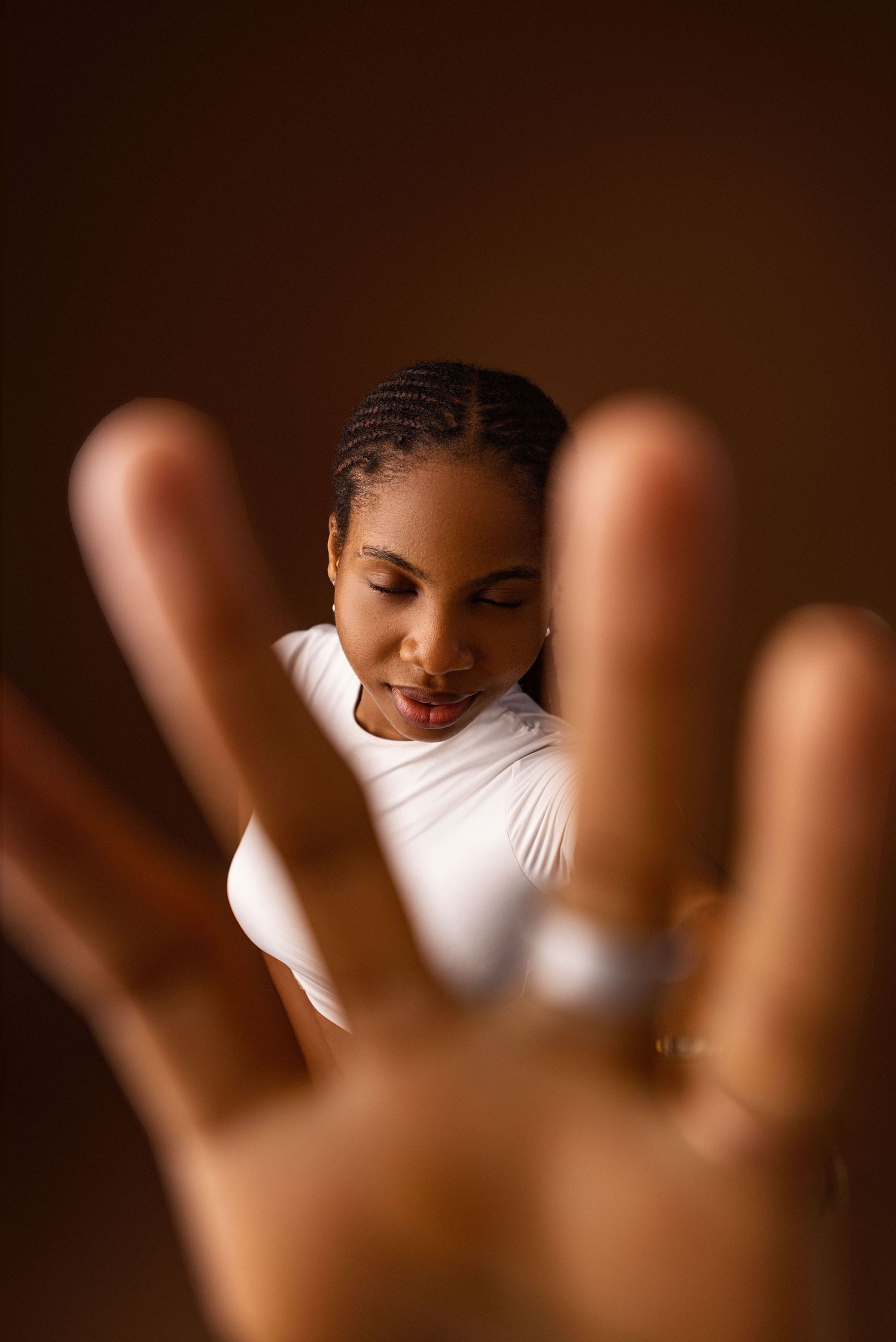 Portrait of a beautiful Nigerian model with her eyes closed and hand close to the camera
