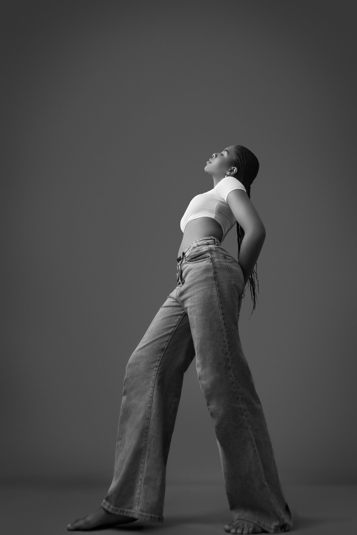 A black and white portrait of a beautiful Nigerian model standing tall shot very below eye level