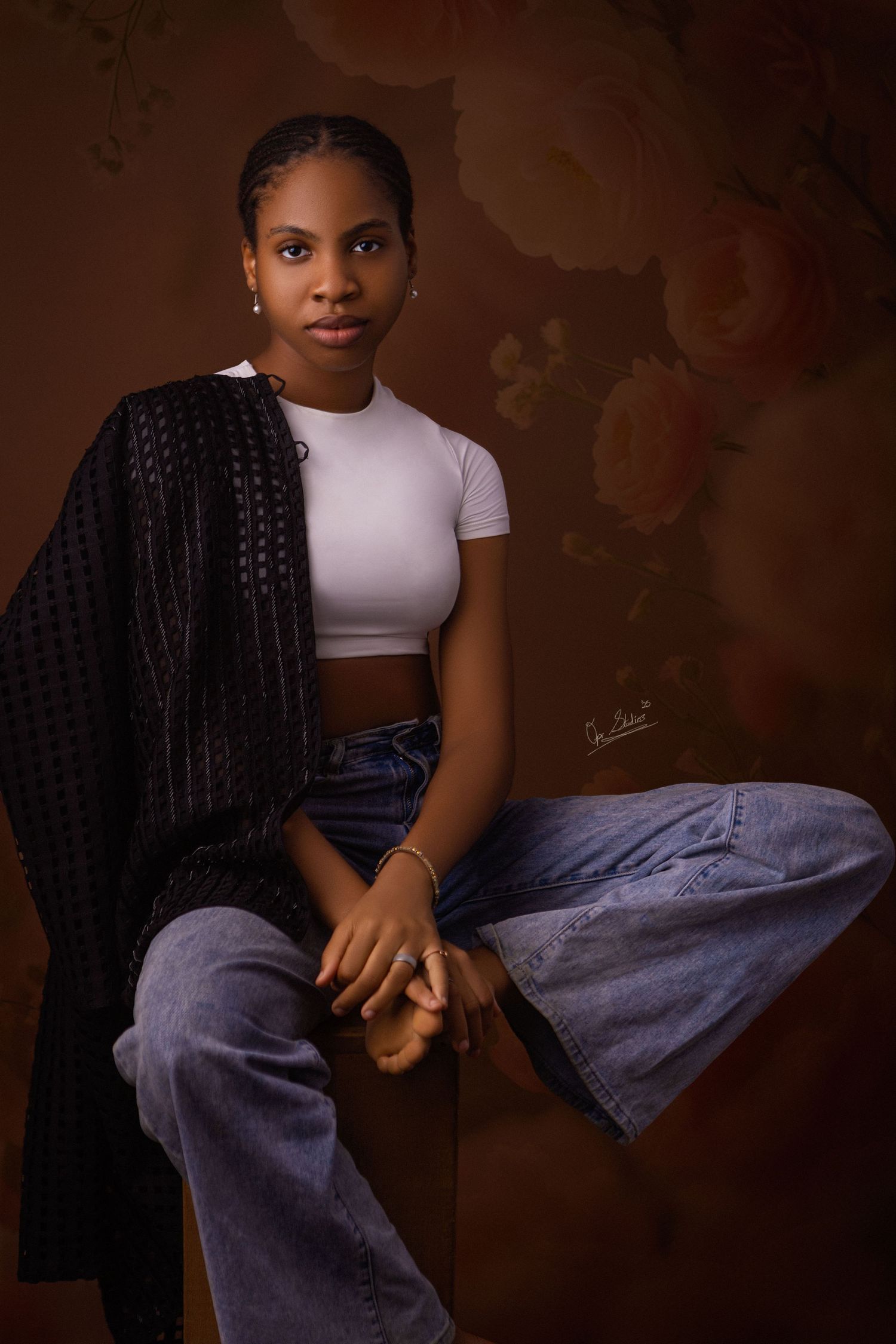 Portrait of a beautiful Nigerian model sitting on a stool with one leg folded on the stool