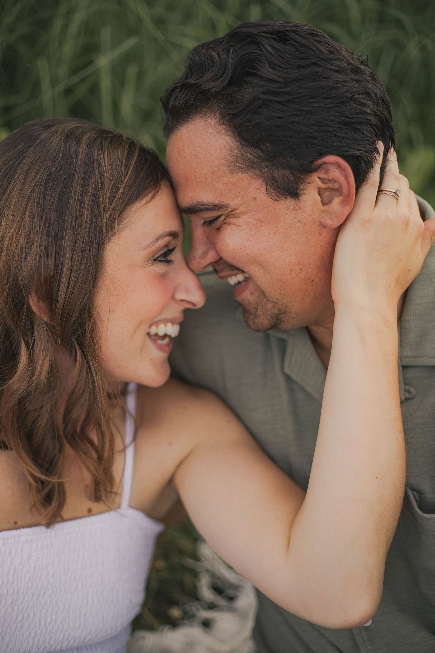 A husband and wife smiling forehead to forehead in a sweet embrace.