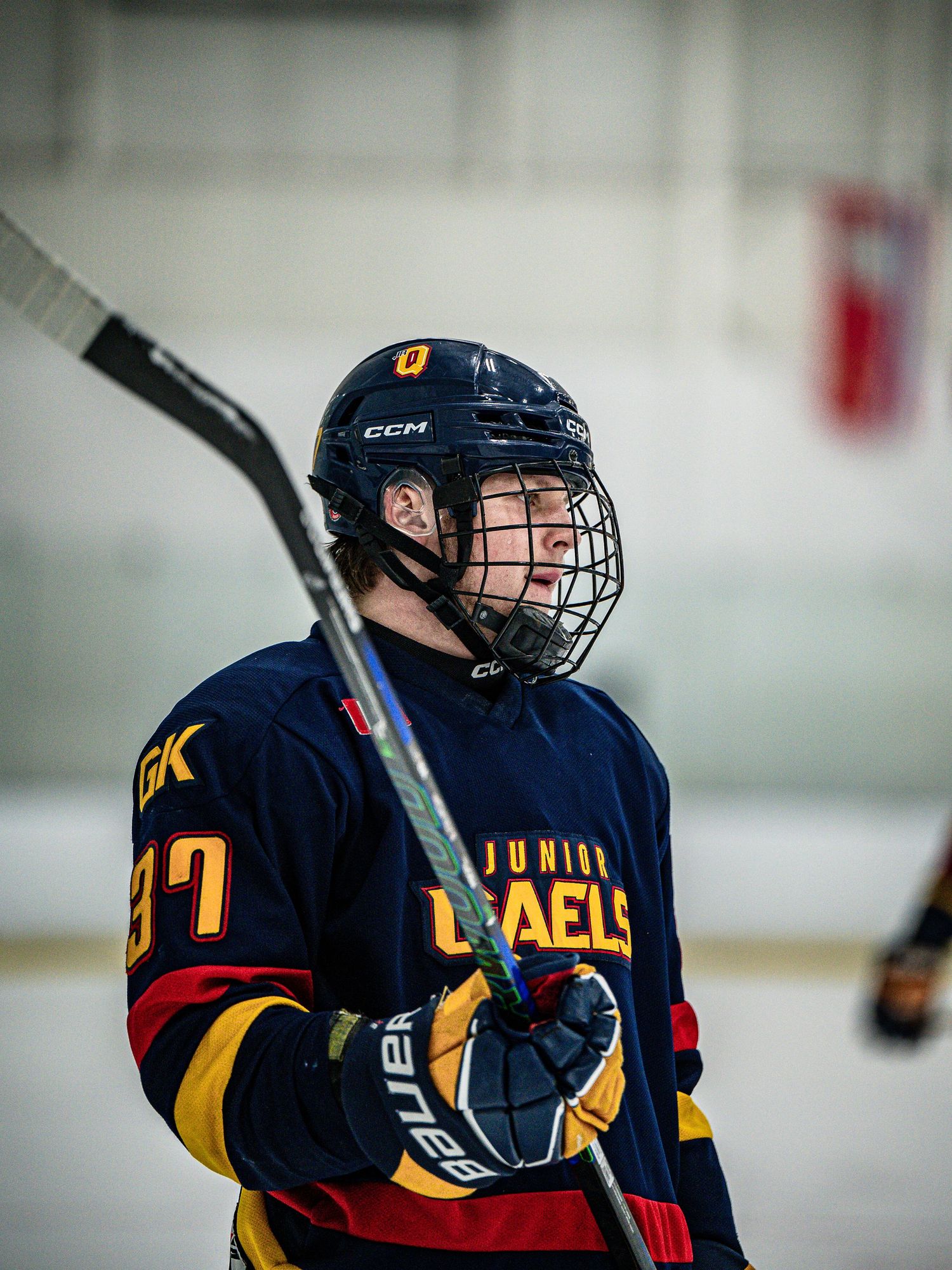 Hockey players in navy and yellow jerseys skate on ice during an intense game session.
