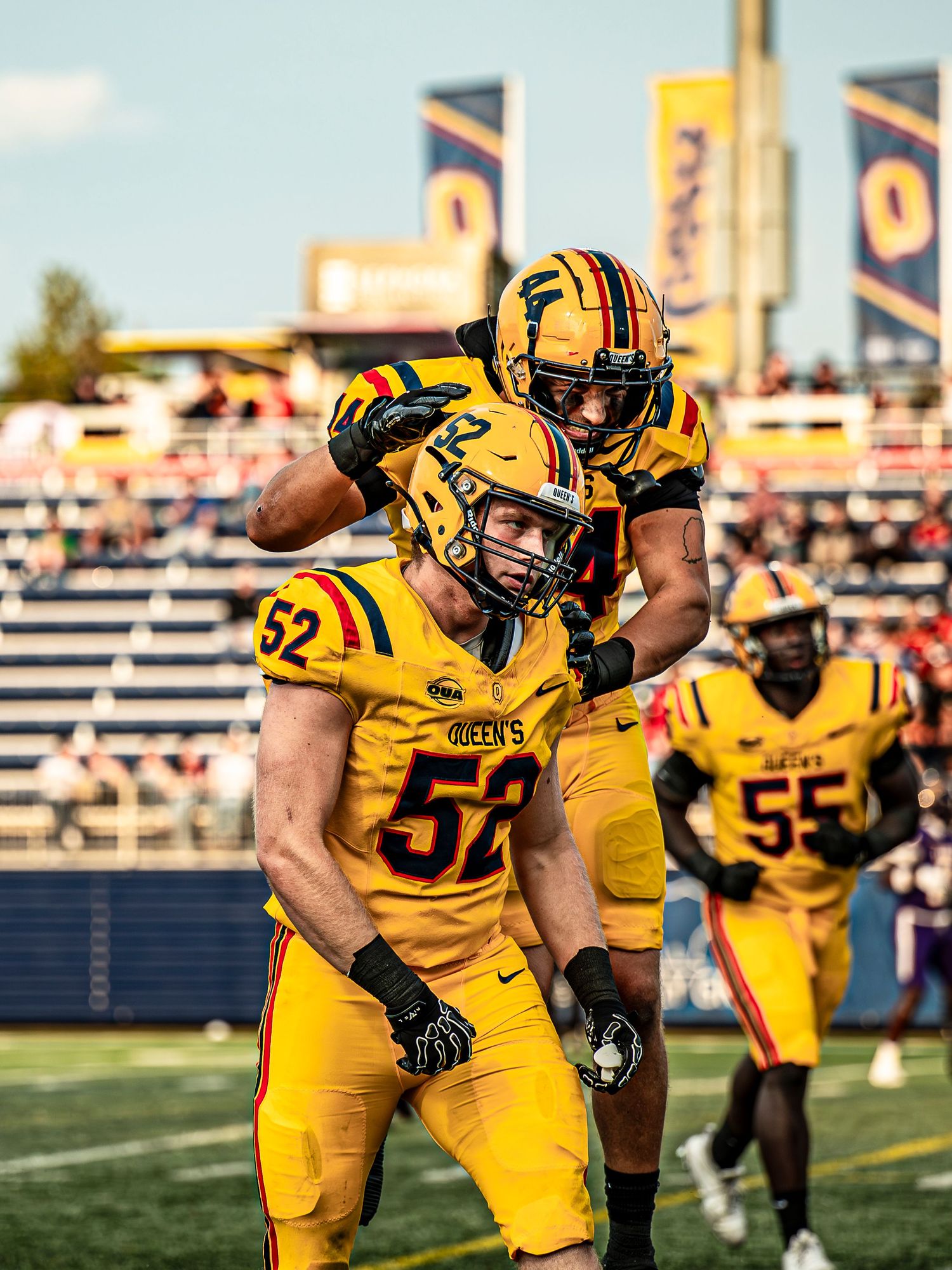 Football players in yellow jerseys line up in formation during game play.