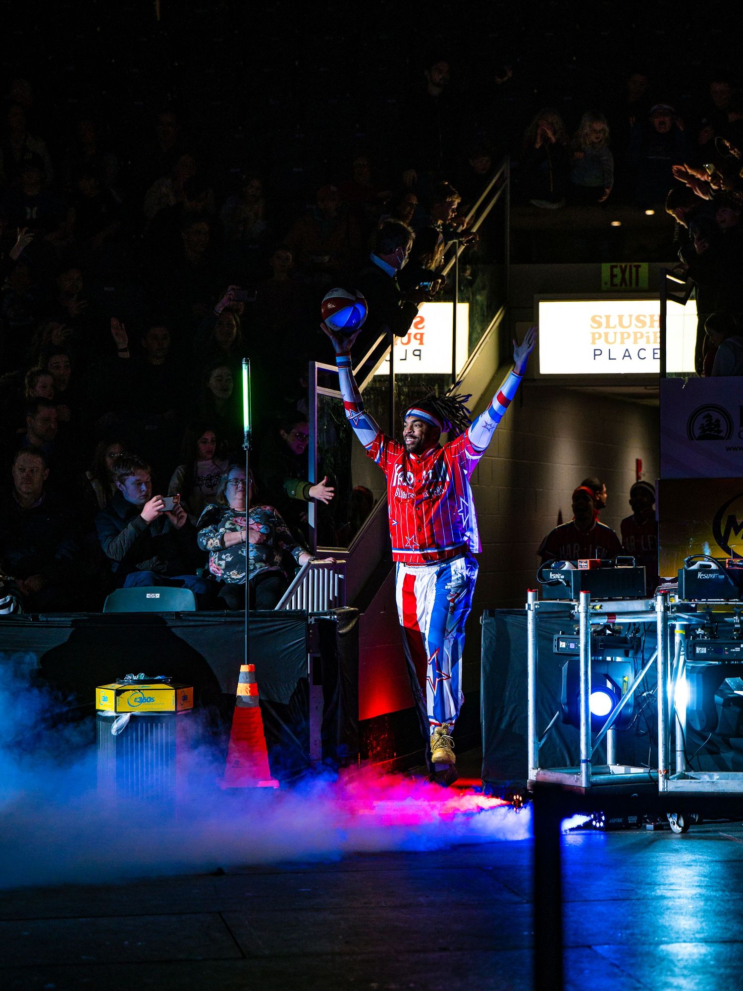 Performers on a dark stage illuminated by dramatic blue and red lighting create an atmospheric nighttime show.