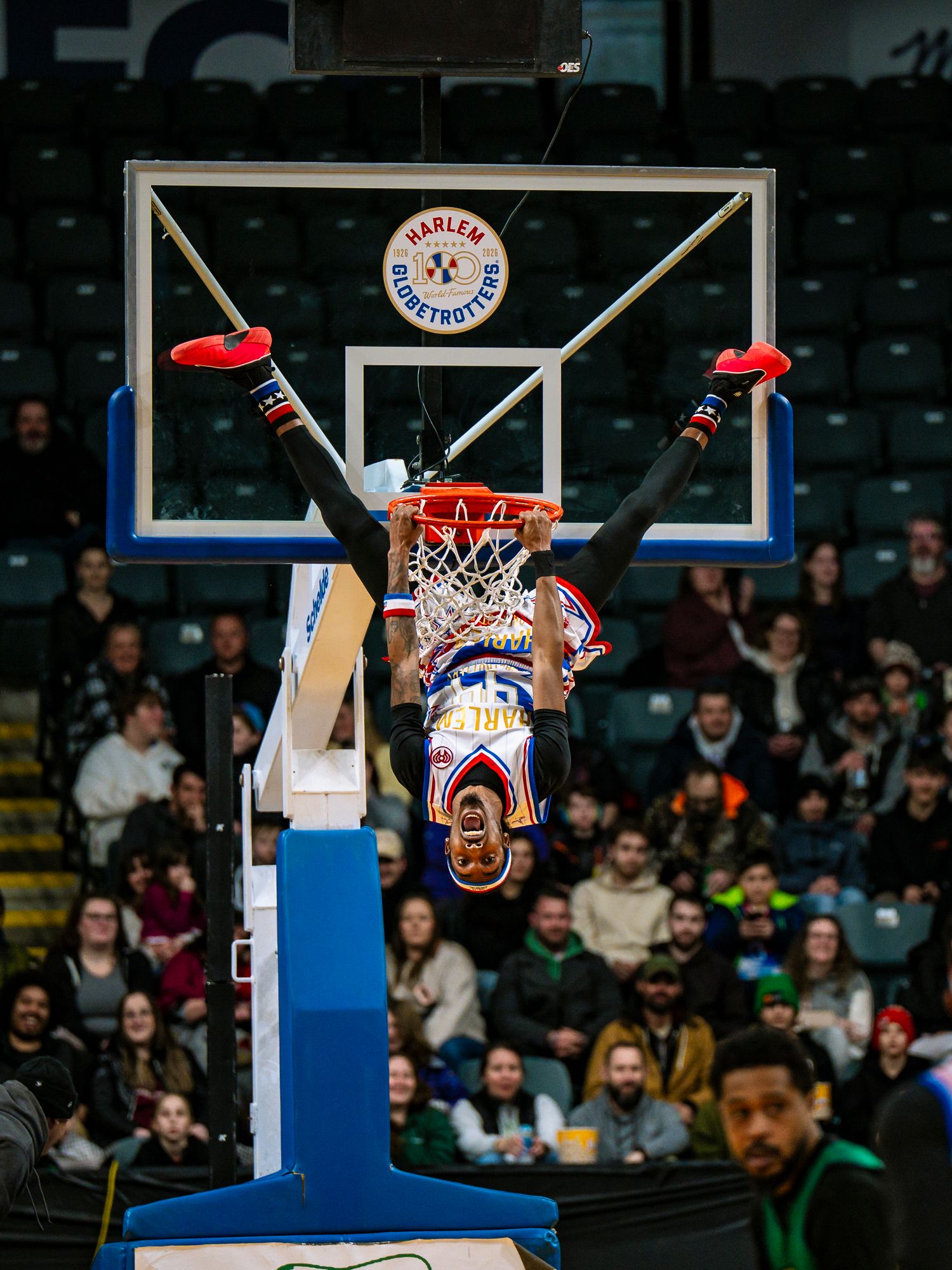 Basketball player soars through the air to make an impressive slam dunk during an indoor game.