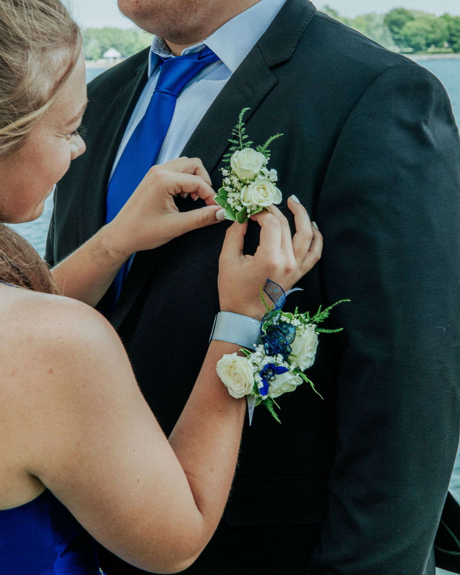 Close-up shots of formal attire with blue accents and white floral boutonniere details.