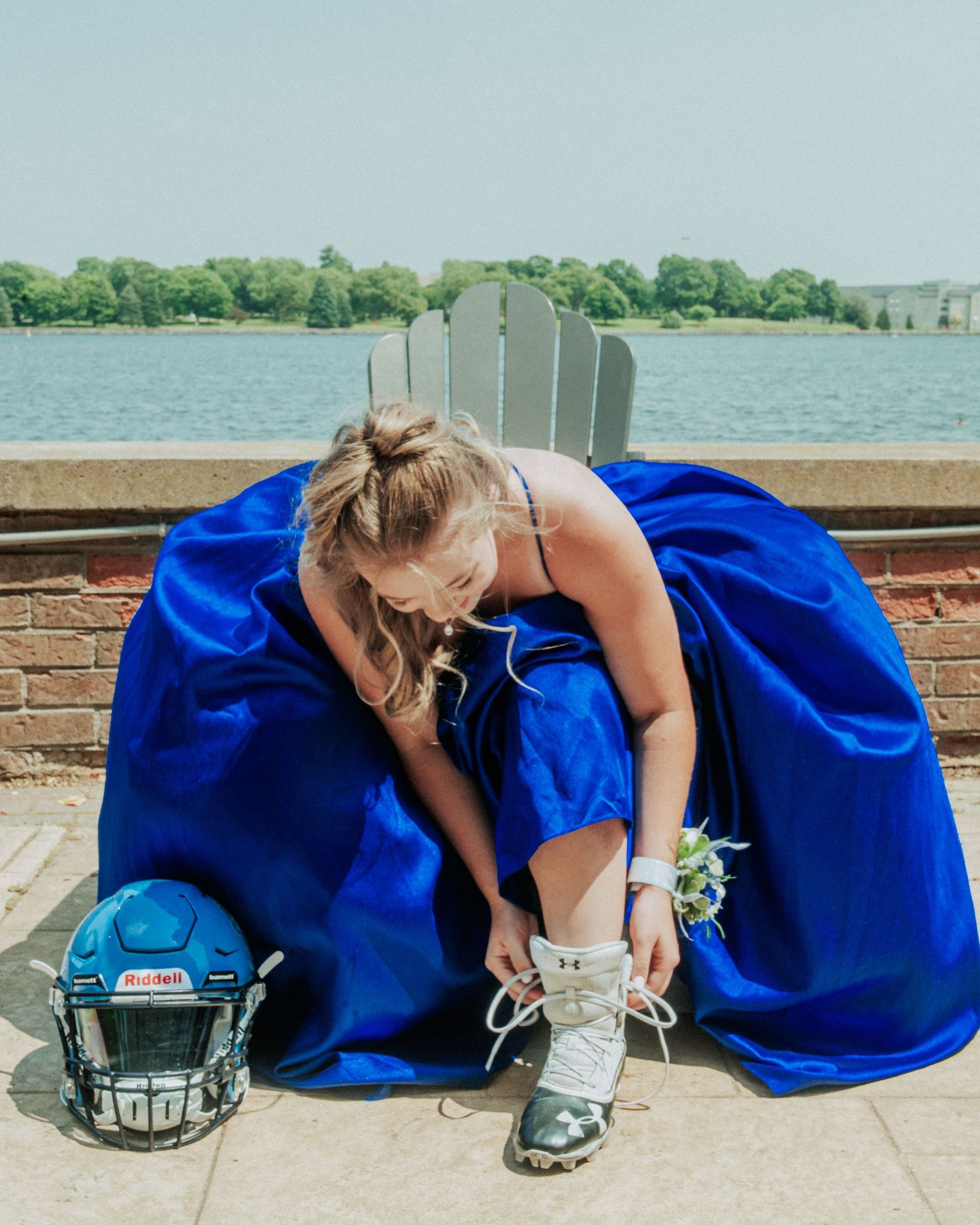 A sequence of photos showing someone adjusting a blue dress while sitting on a brick ledge near water.