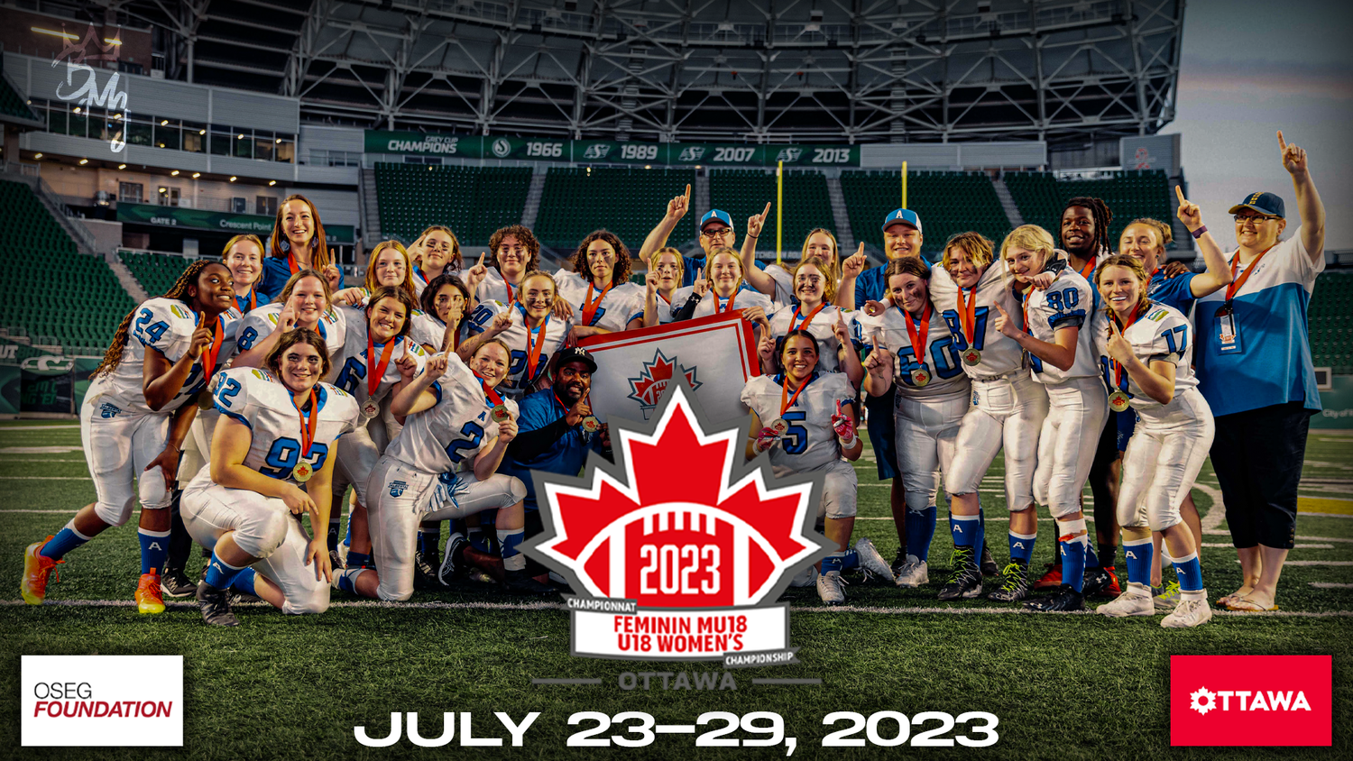 Football players in white uniforms celebrate on a field during a sports event at a stadium.