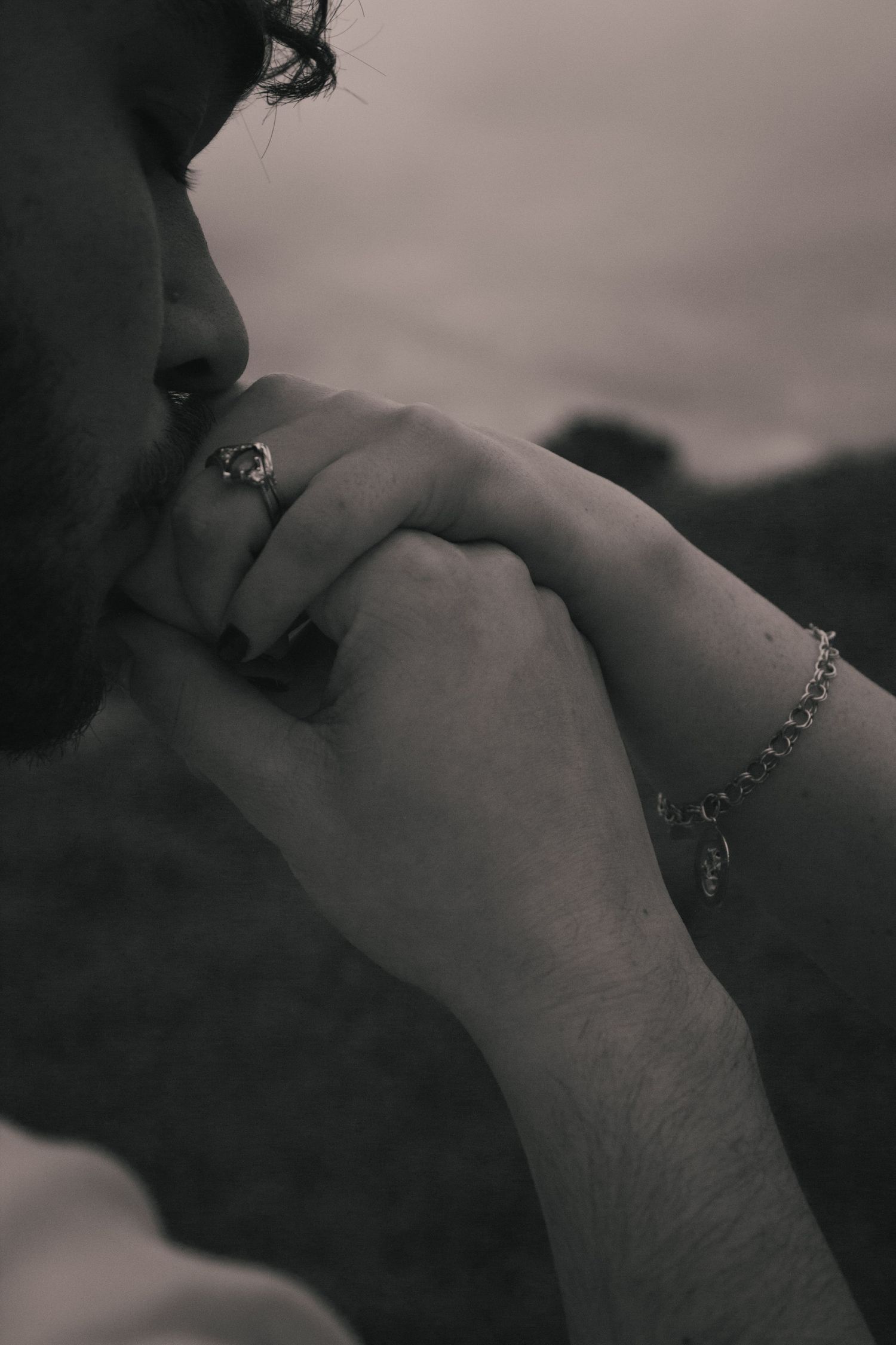 Black and white artistic photo series showing close-up detail of a kiss to the hand.