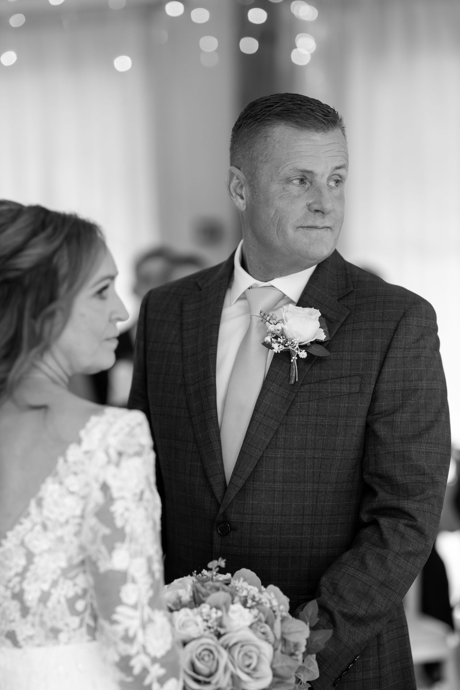 Black and white emotional wedding ceremony moments with bokeh lights in background.