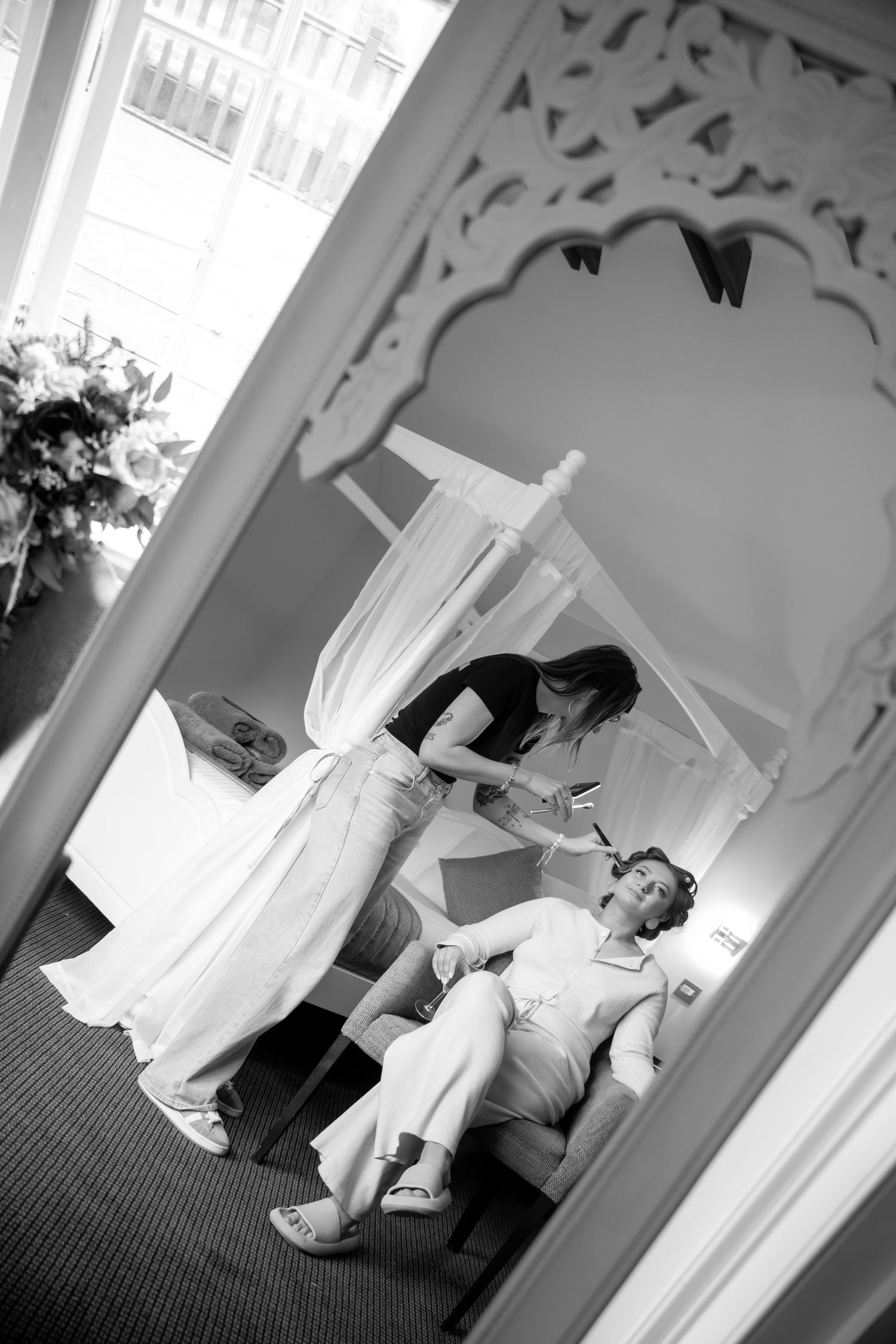 A series of black and white photos showing someone lying on the floor near white curtains and ornate wall trim.