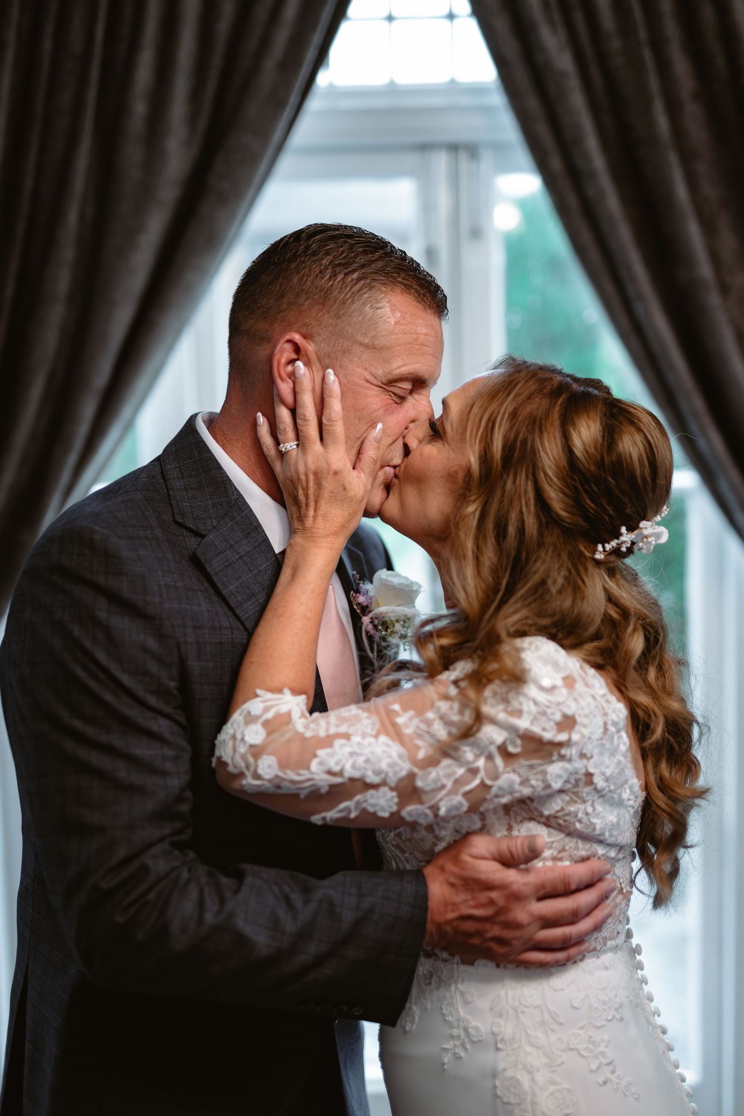 Sequence of romantic wedding kiss photos in front of window with dark curtains.