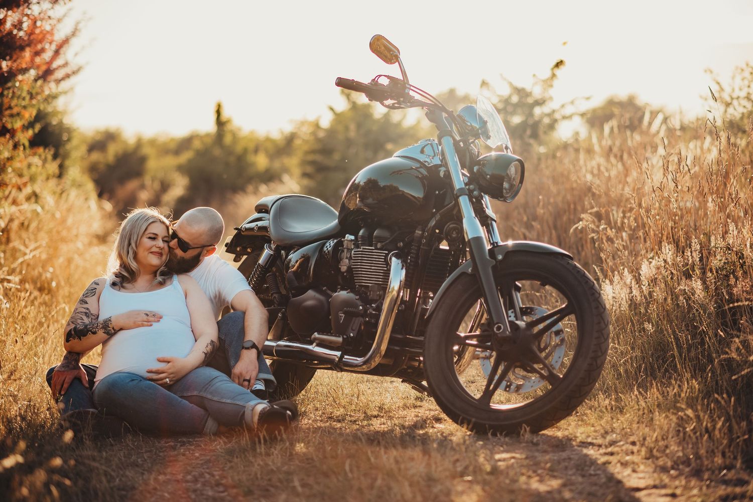 Classic motorcycle silhouetted against a natural landscape at sunset.