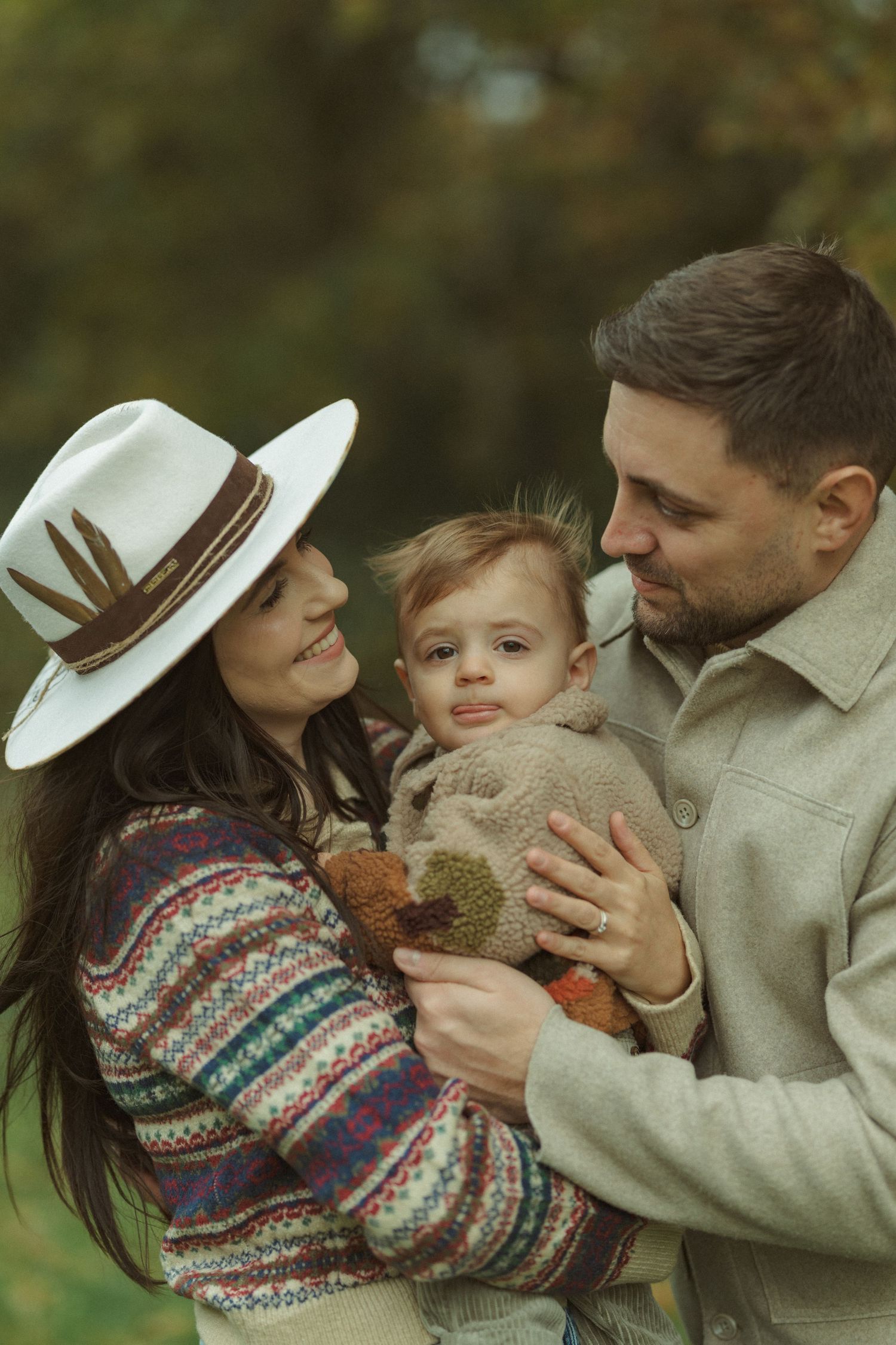 Candid family moments with toddler in cozy fall outfits against autumn backdrop.