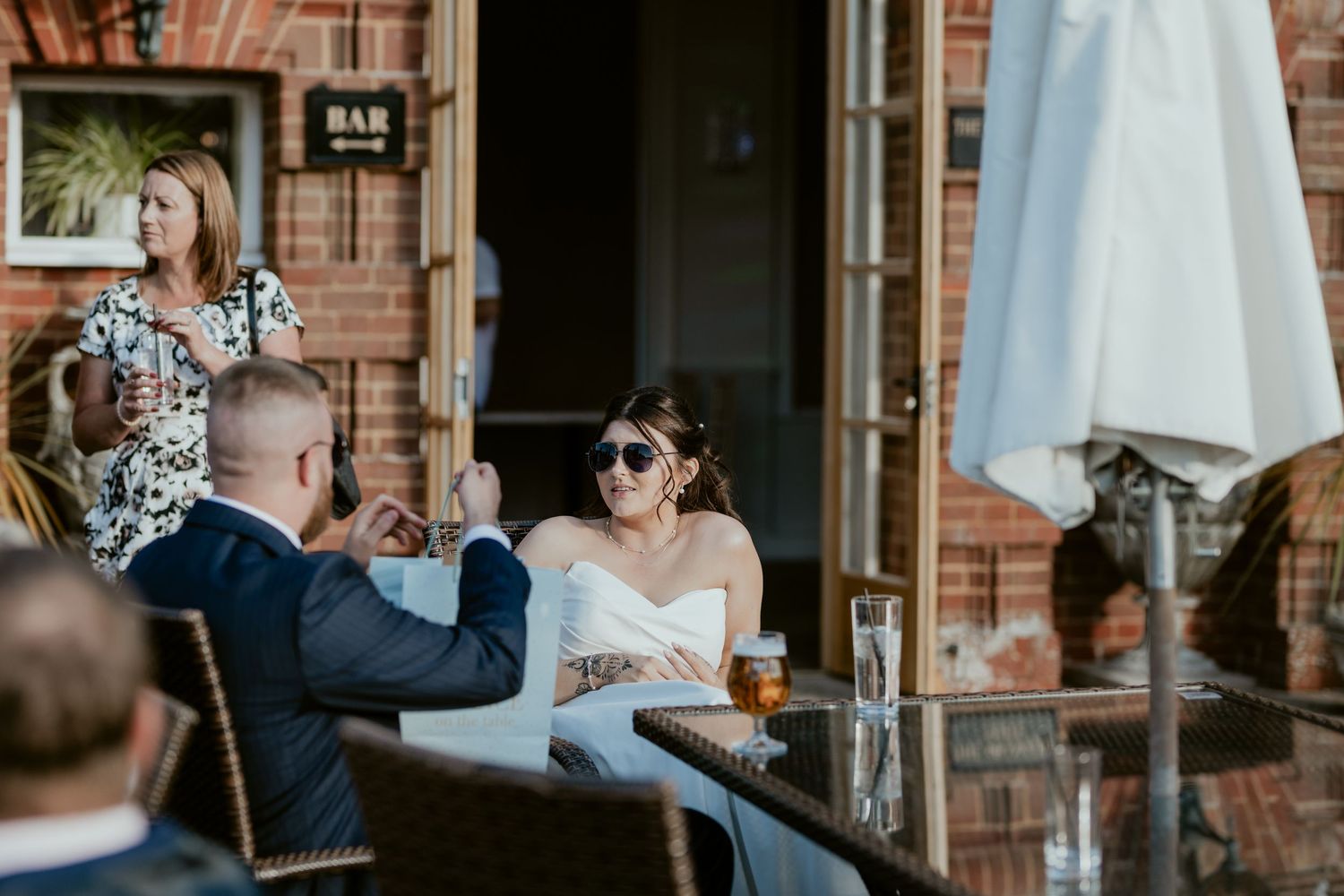Wedding guests enjoying drinks and conversation at a rustic brick venue.
