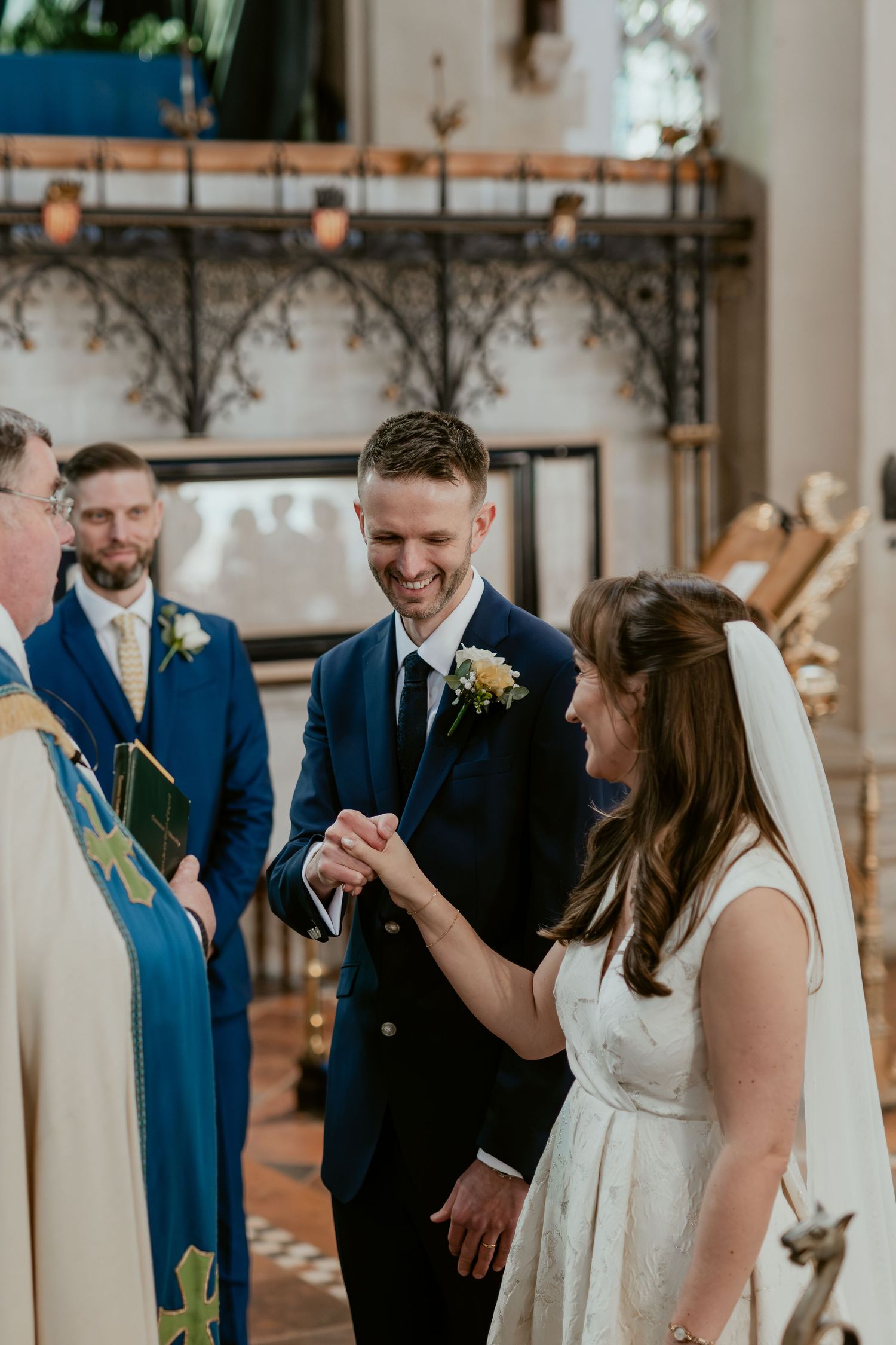 Joyful moments during a church wedding ceremony with guests in blue suits and white decor.