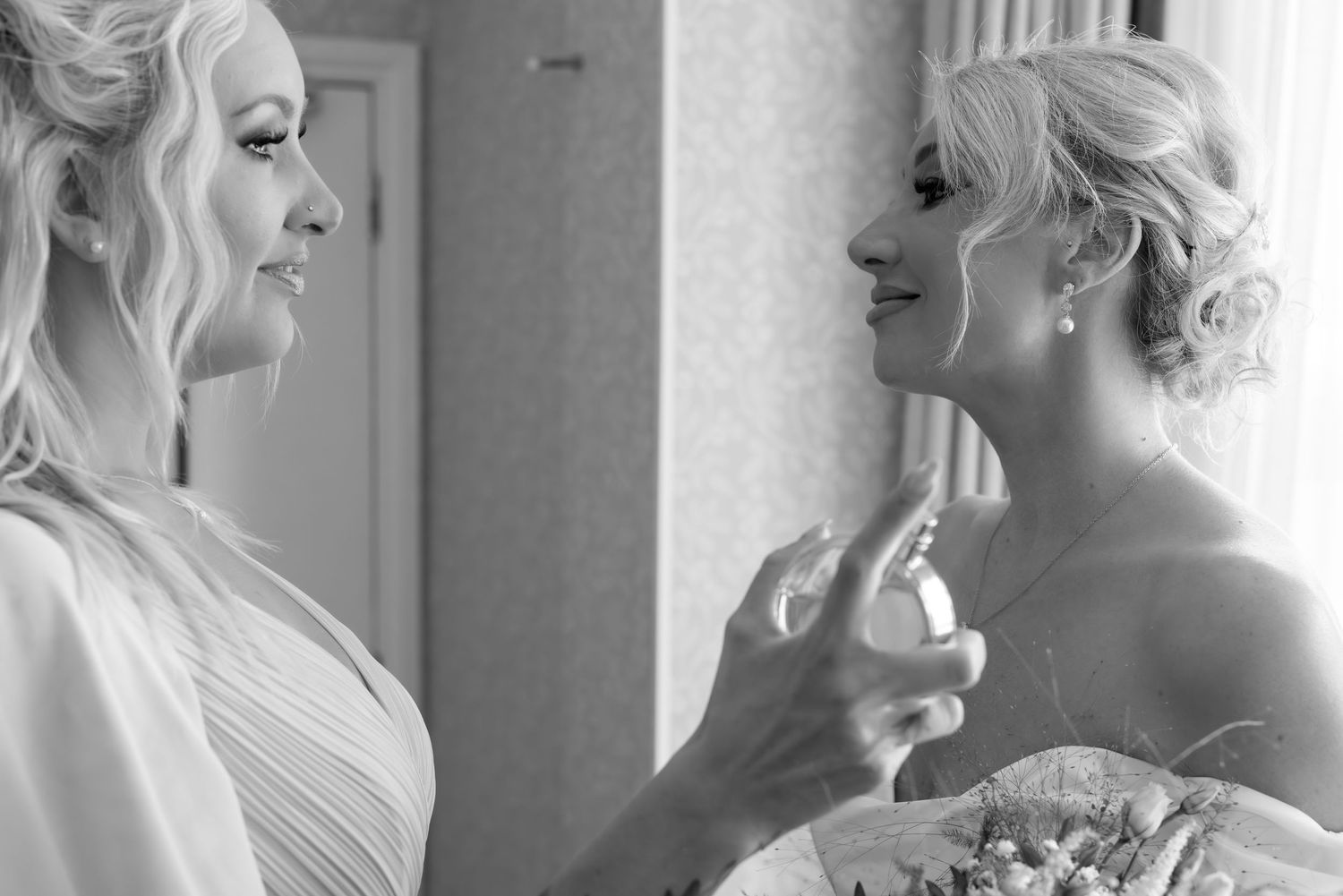 Bridesmaids in elegant dresses share candid moments during wedding preparations.
