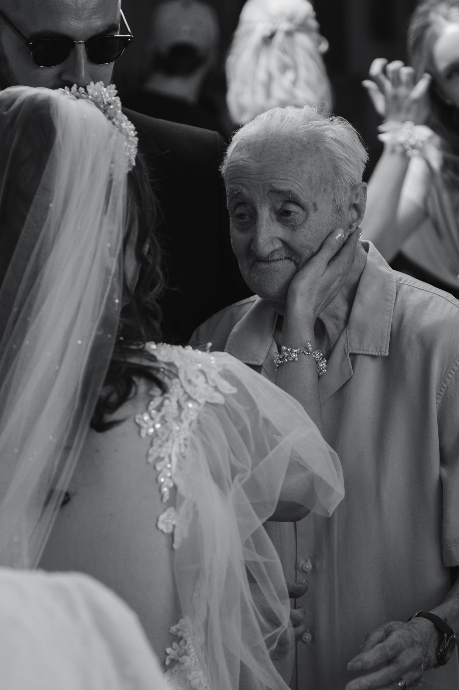 Black and white candid shots capture emotional reactions during a wedding ceremony.
