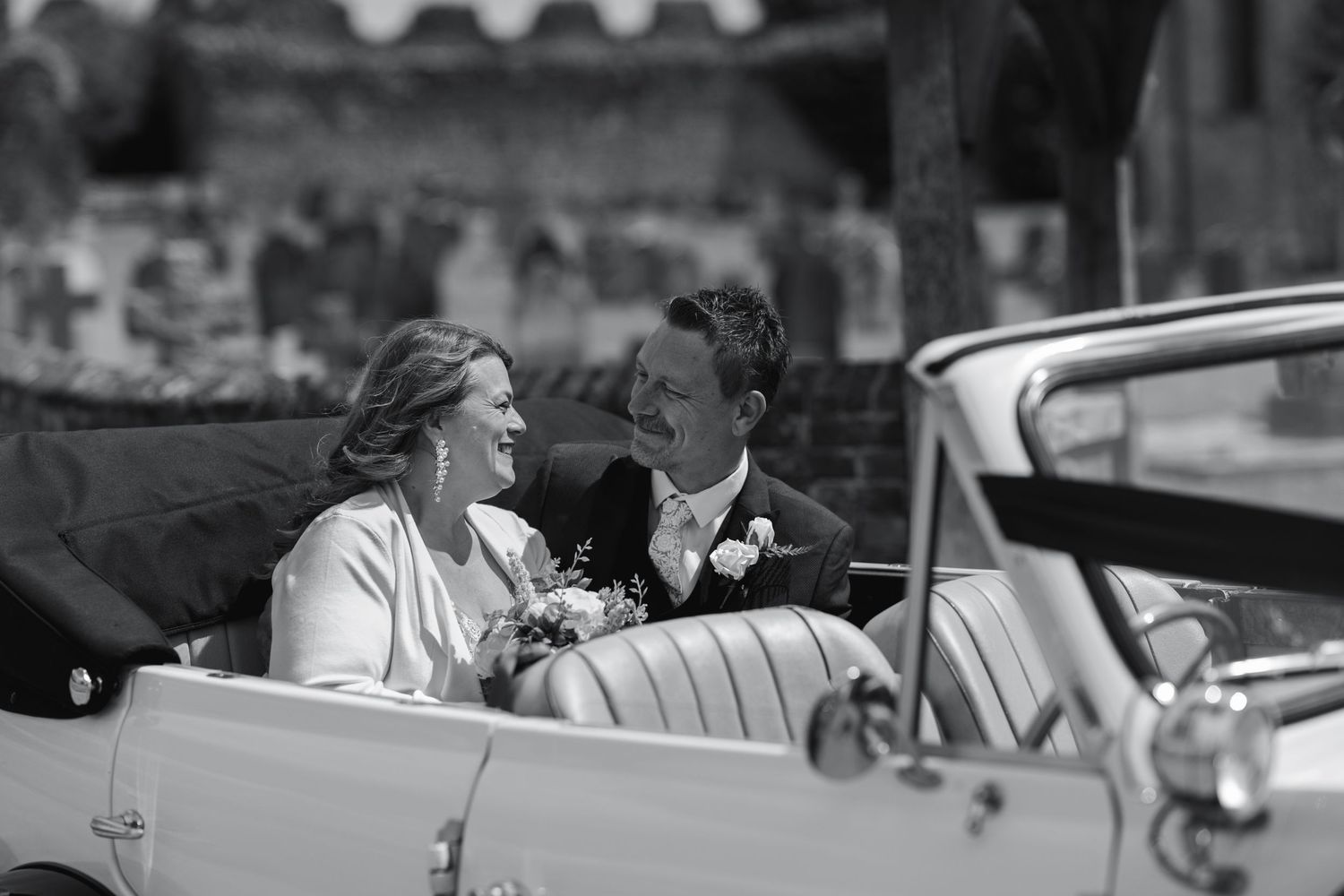 Vintage-style black and white wedding portraits with classic cars in background.