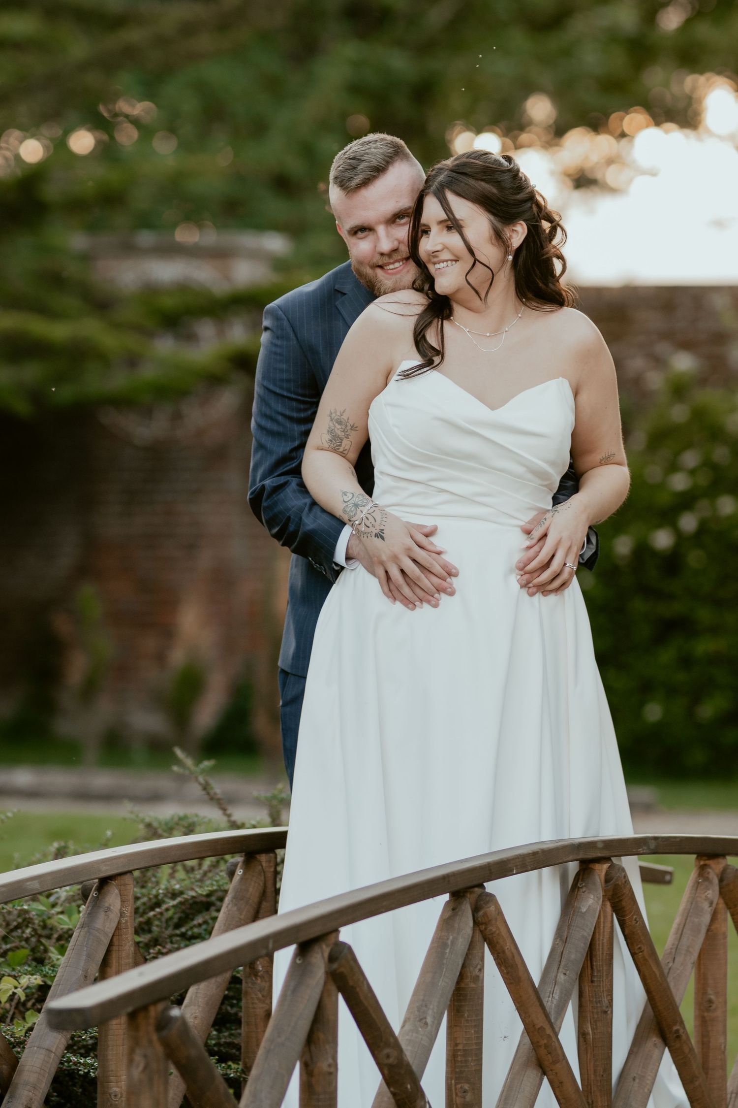 Romantic moments shared between newlyweds on a wooden bridge in a garden.