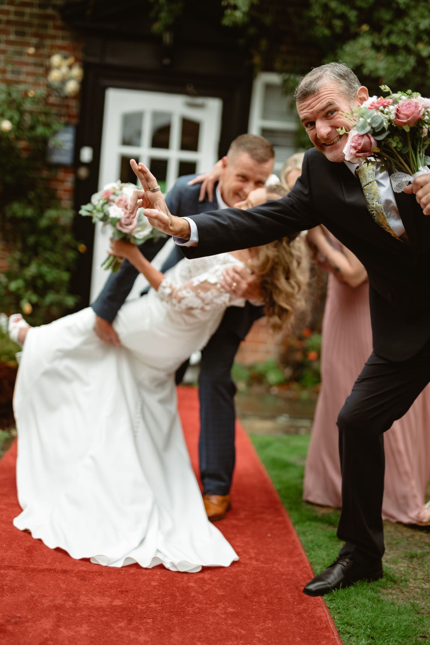 Couple strikes dramatic kung fu inspired poses during wedding photoshoot on red carpet.