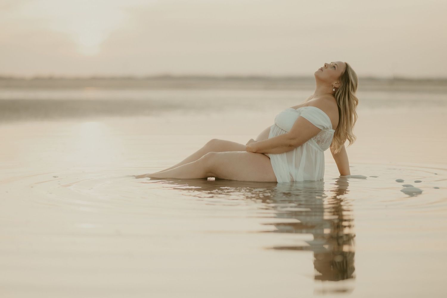 Ethereal water photography session with soft beige tones and reflections.