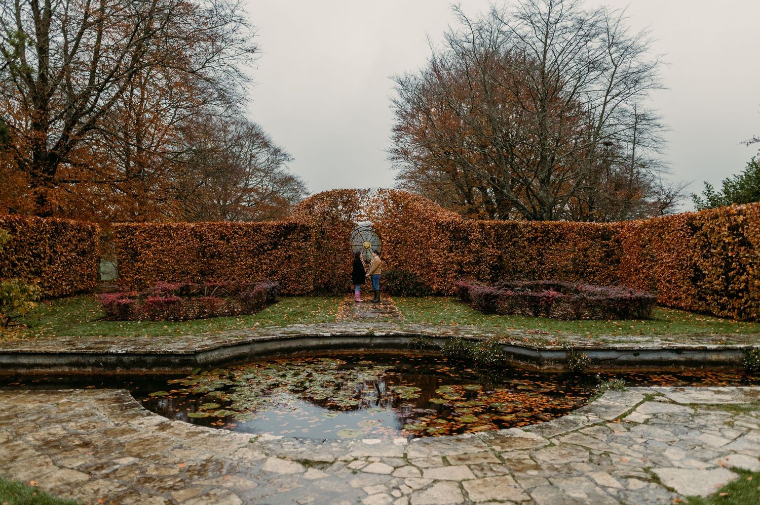 Stone wall and steps covered in fallen leaves during autumn season.