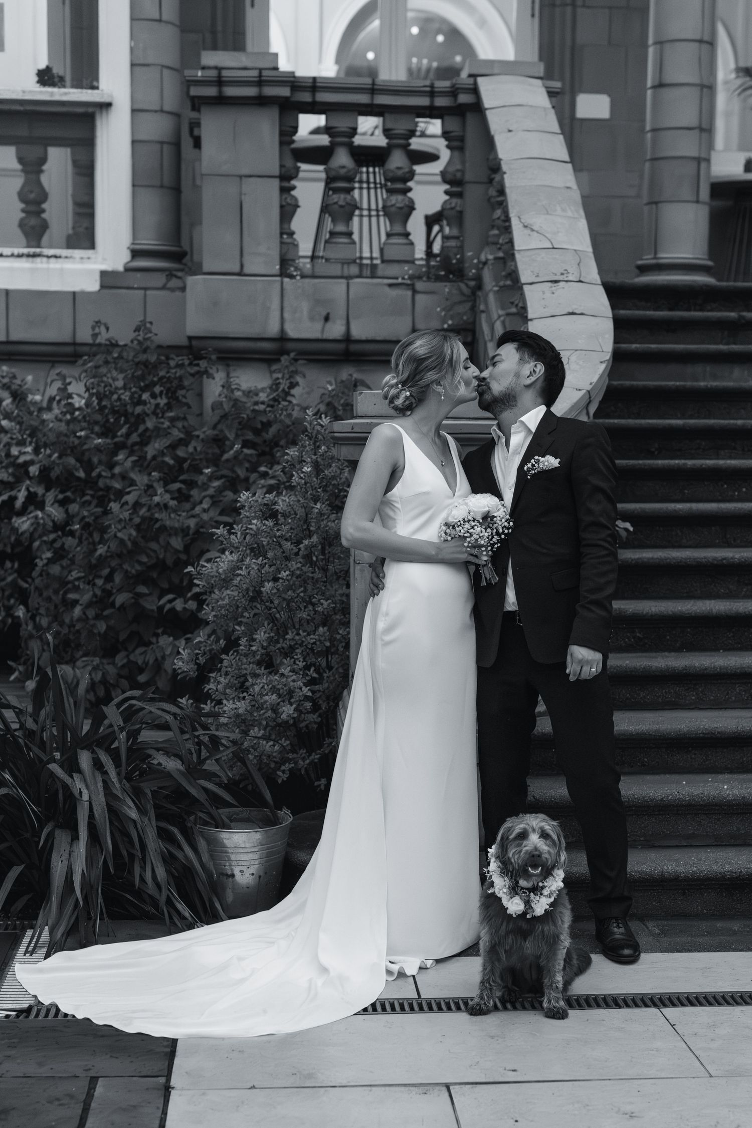 Black and white wedding portraits on elegant stone building steps.