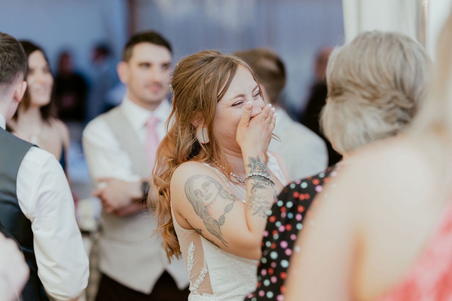Wedding guests dance and celebrate together on a lively dance floor during an evening reception celebration.