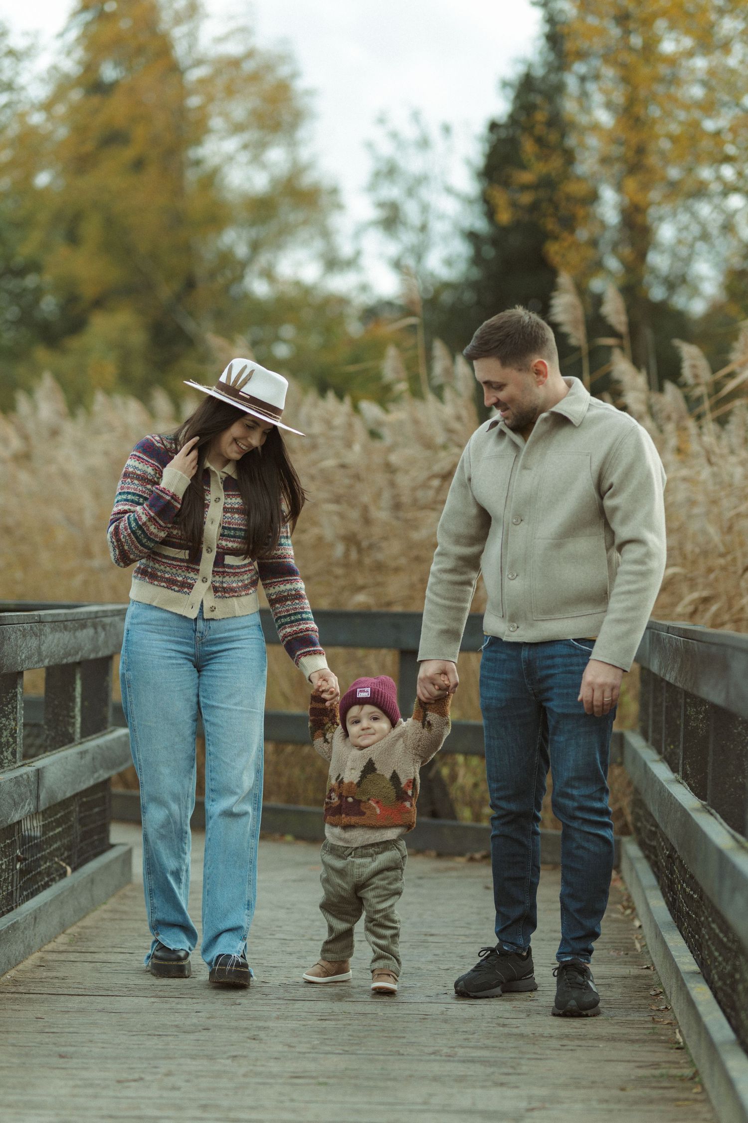 People walking together on a wooden boardwalk during a fall afternoon.