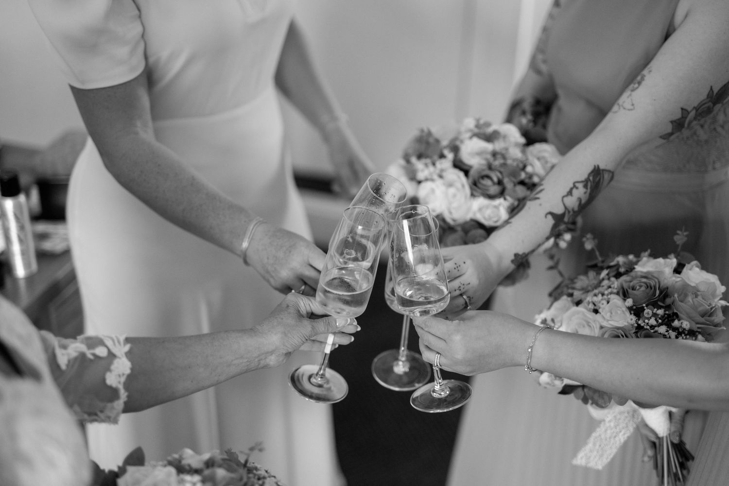 Wedding reception details with champagne glasses and table settings in black and white.