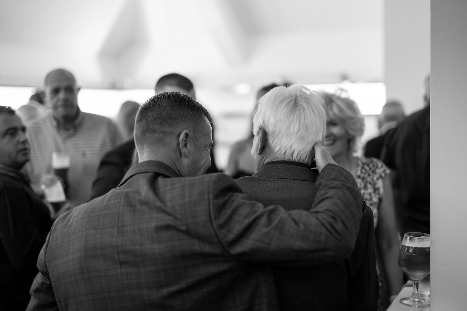 Black and white photo of wedding guests watching entertainment at reception.