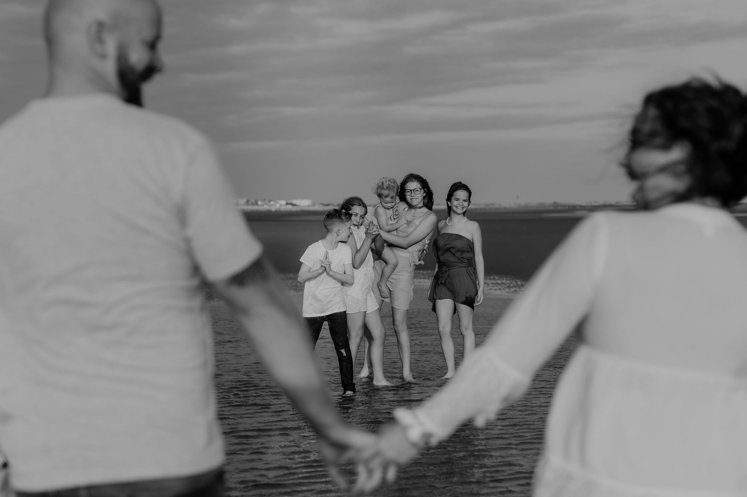 Black and white photo of family enjoying time together by the water.