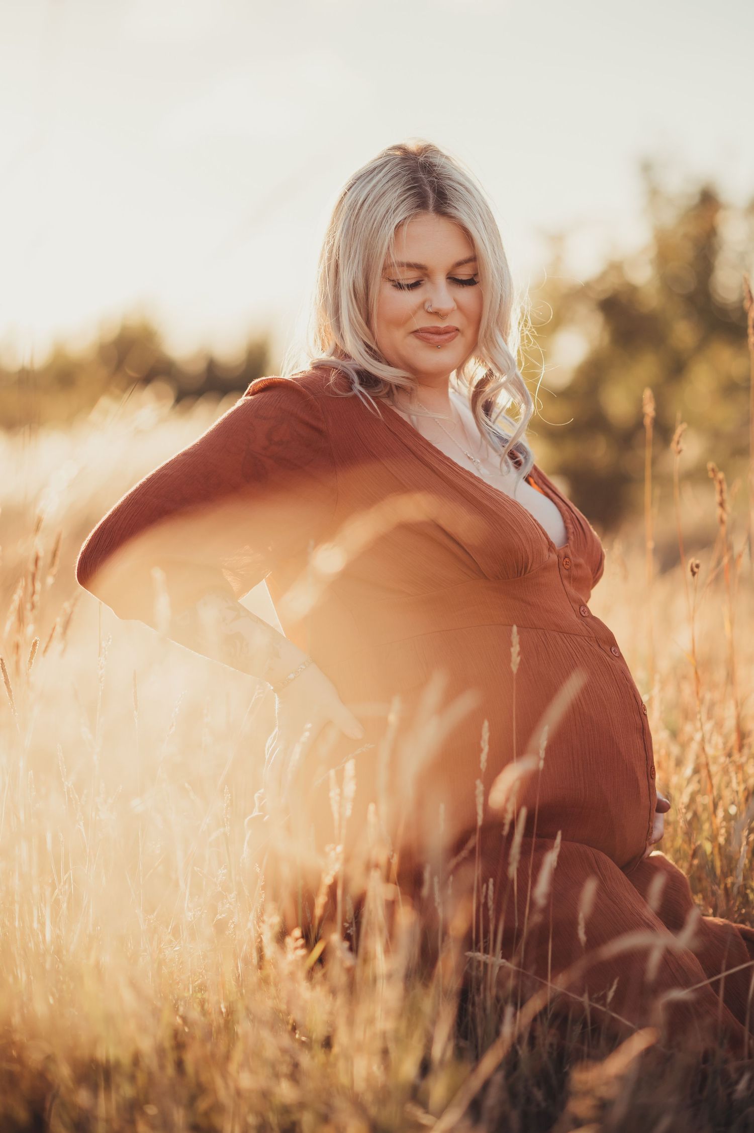 Ethereal sunset portrait through golden wheat field with warm lighting.