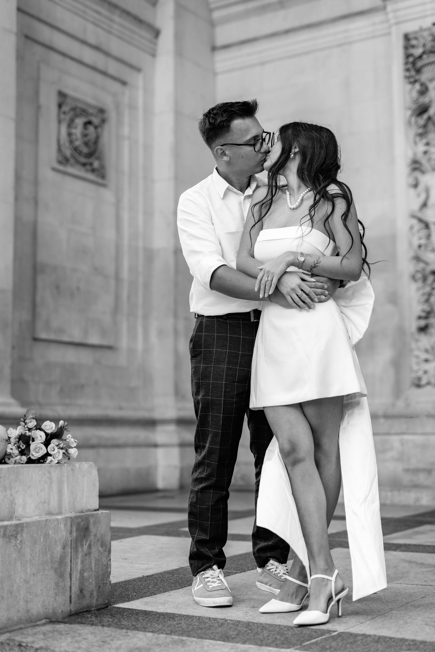 Black and white photo series captures romantic moments between couple on stone steps.