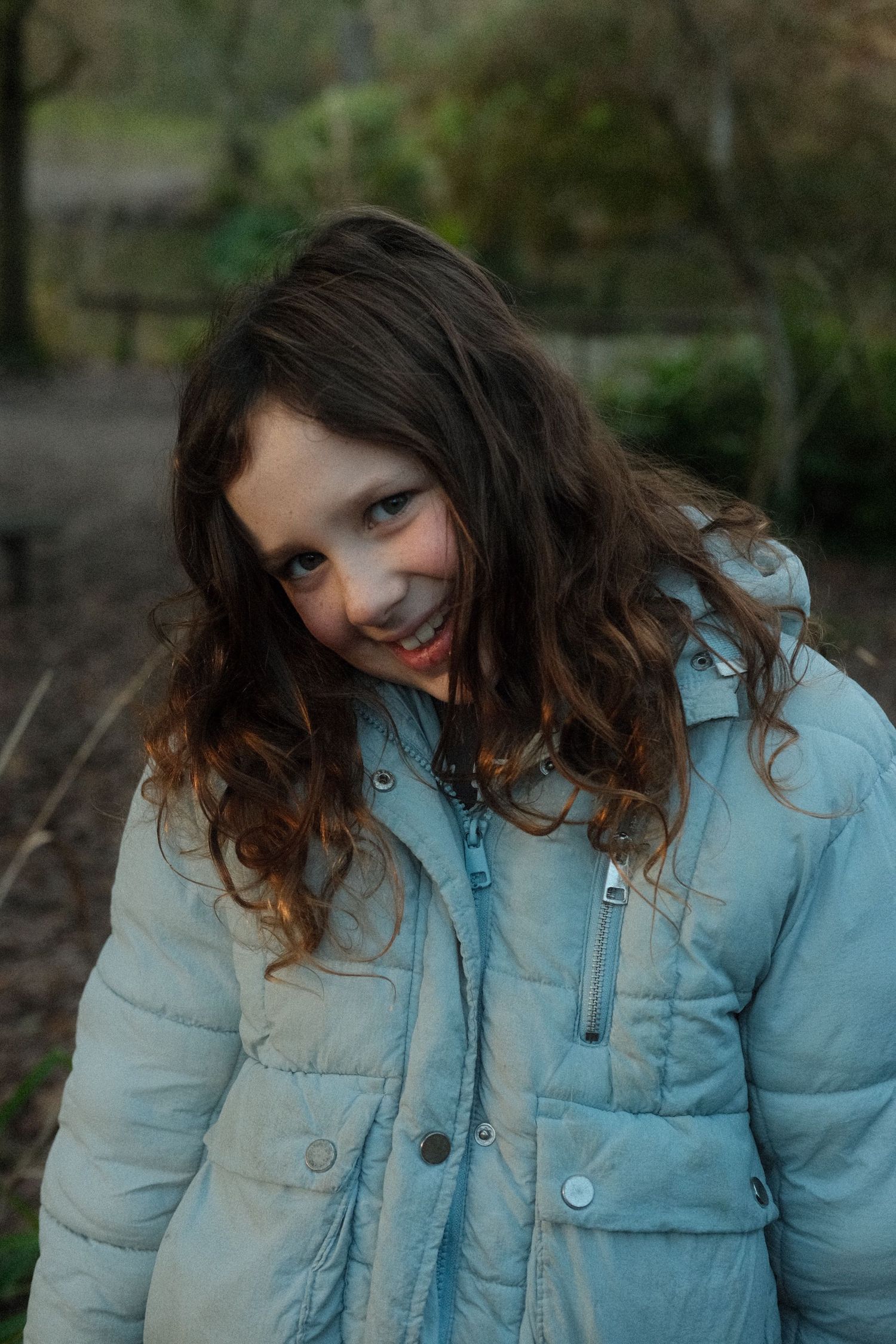 Portrait series showing playful expressions while wearing a light blue winter jacket.