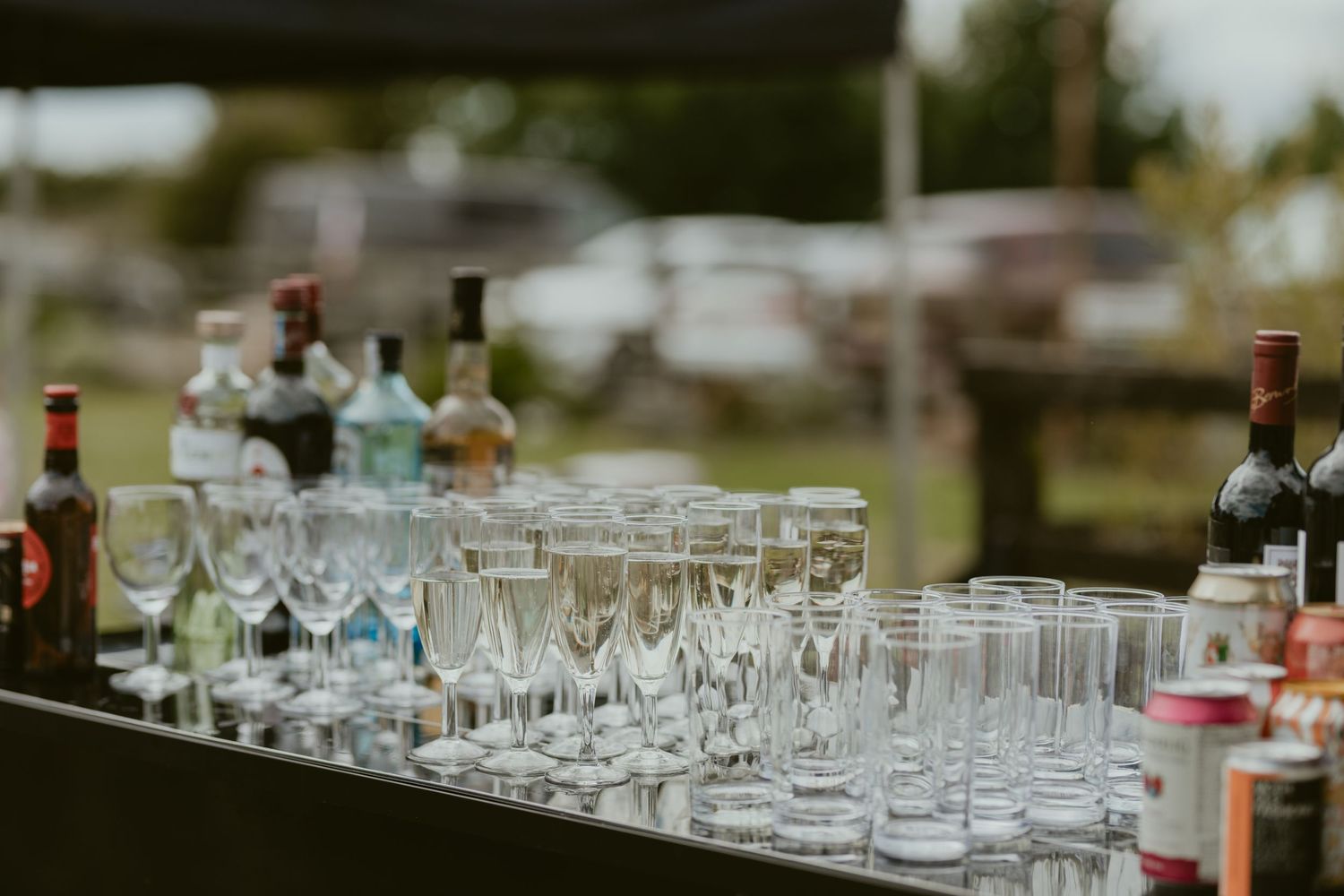 Bar setup with various glasses and bottles arranged for wedding reception.
