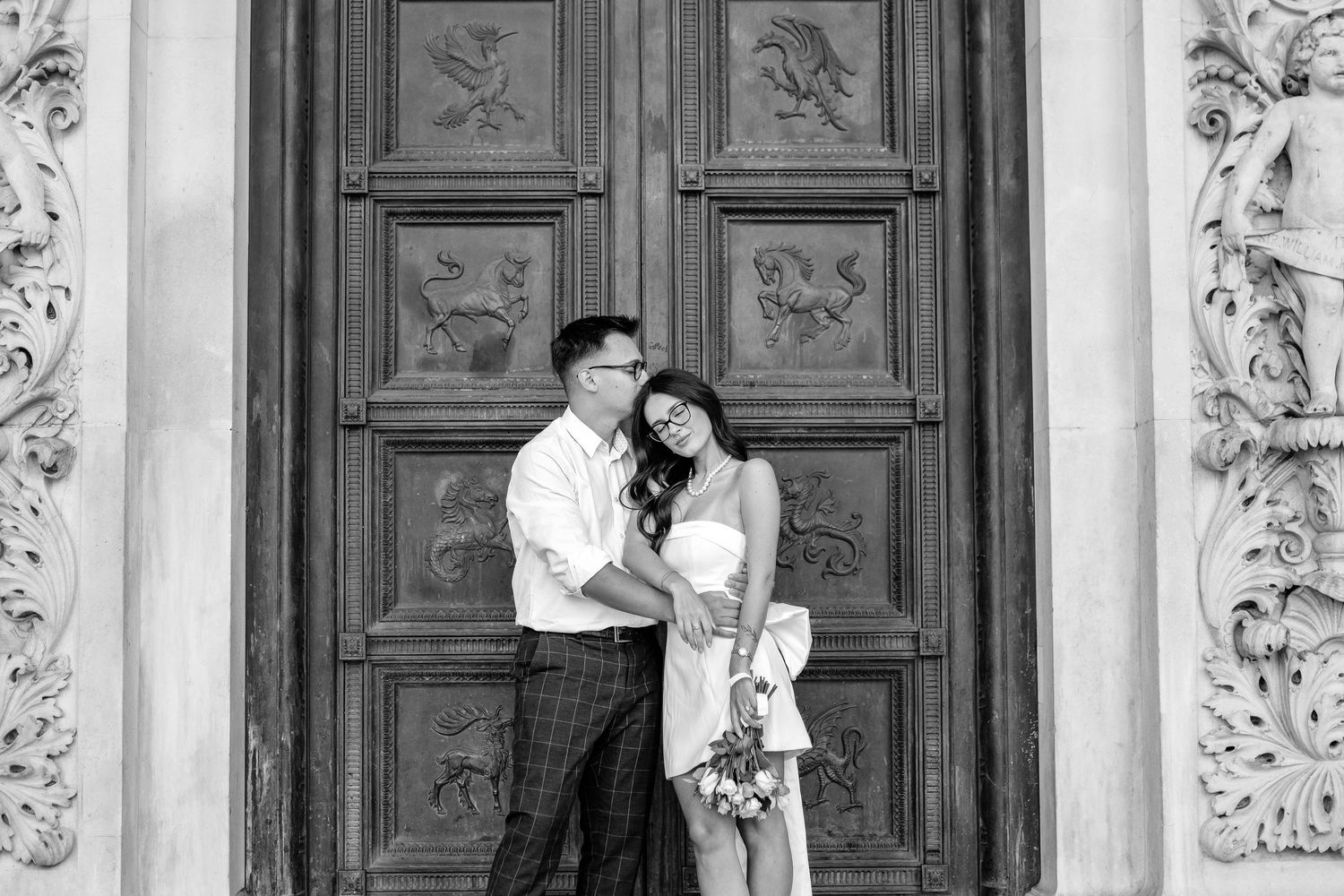 Elegant black and white wedding portrait series against ornate architectural details and columns.