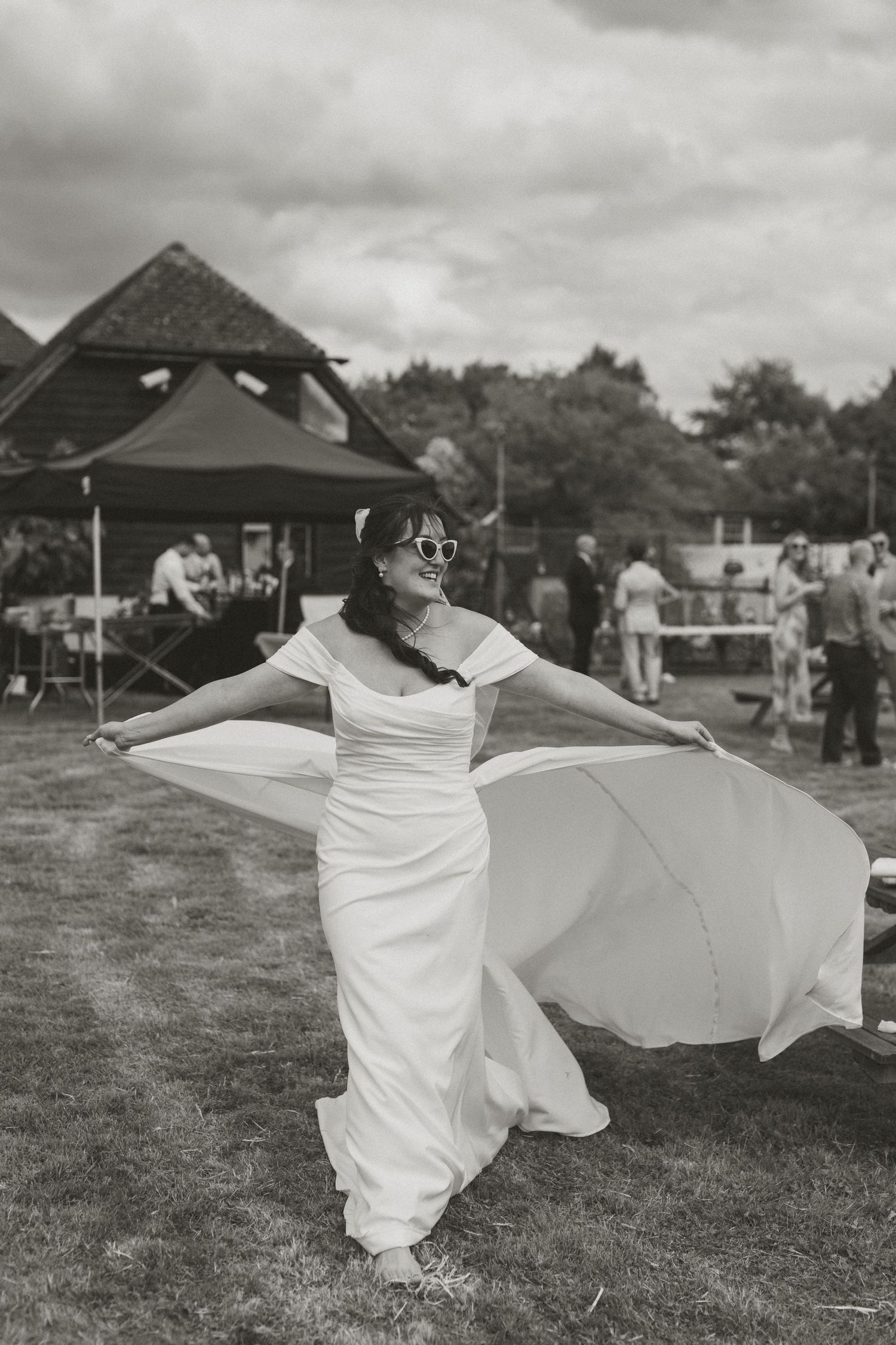 Black and white photos of a bride twirling in her dress on a grassy field.