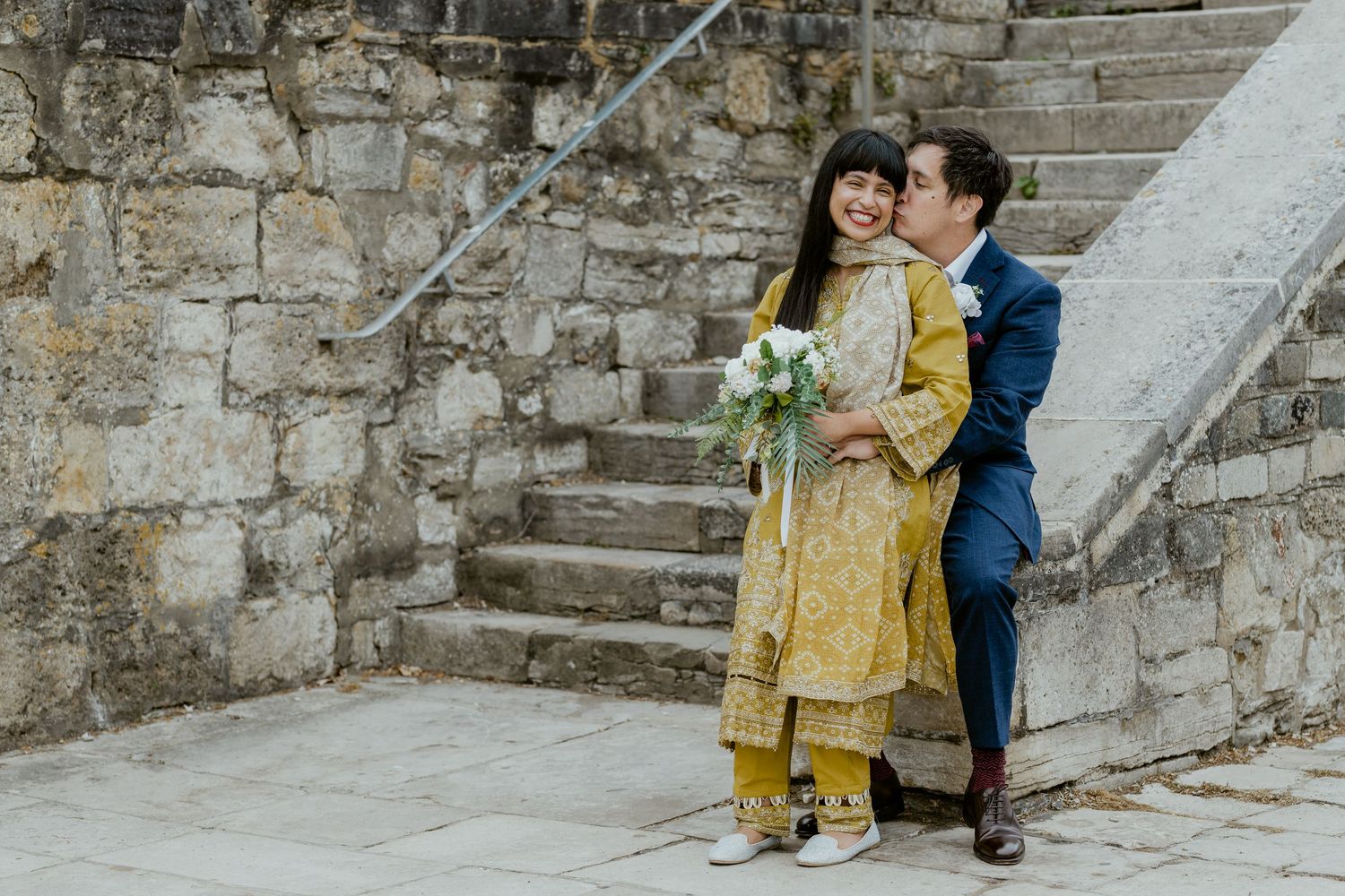 Family photoshoot on historic stone steps with person in yellow outfit.