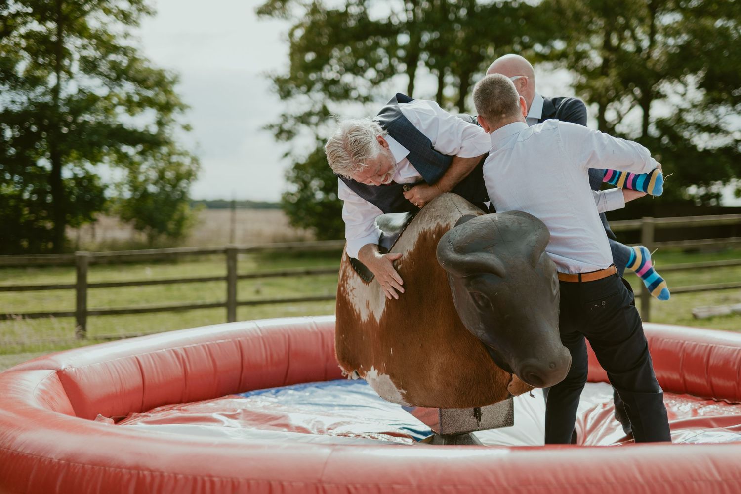 Two people enjoying a mechanical bull ride at an outdoor event.
