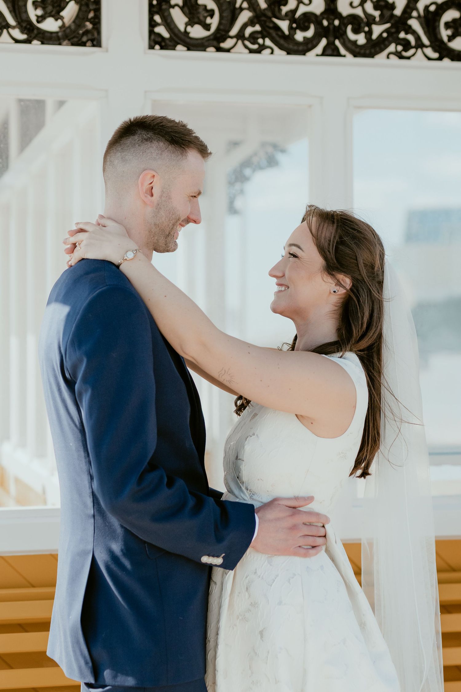 Couple shares romantic moments in a bright indoor venue with ornate details.