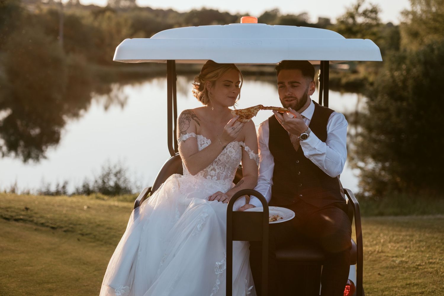 Couple shares romantic moment in golf cart during sunset at wedding venue.