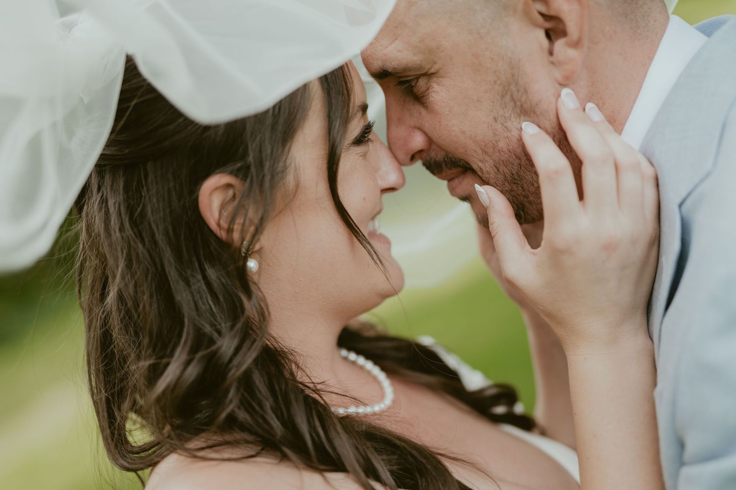 Tender moment between newlyweds captured in soft natural lighting.