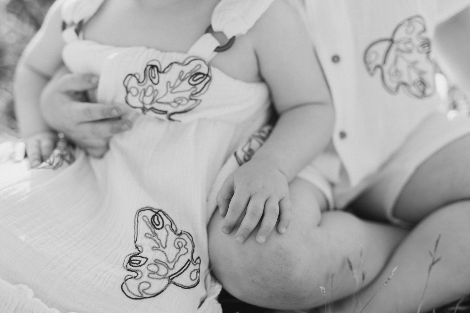 Close-up of children wearing white clothing with decorative designs.
