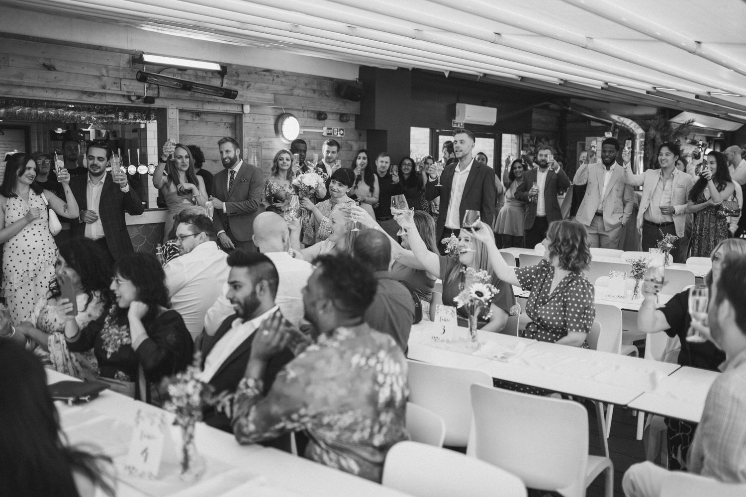 Wedding reception guests enjoying a celebration in an indoor venue.