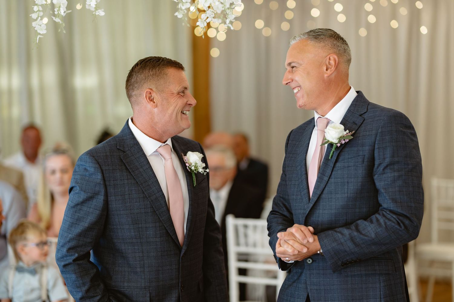 Indoor wedding reception with string lights and elegant white decor.