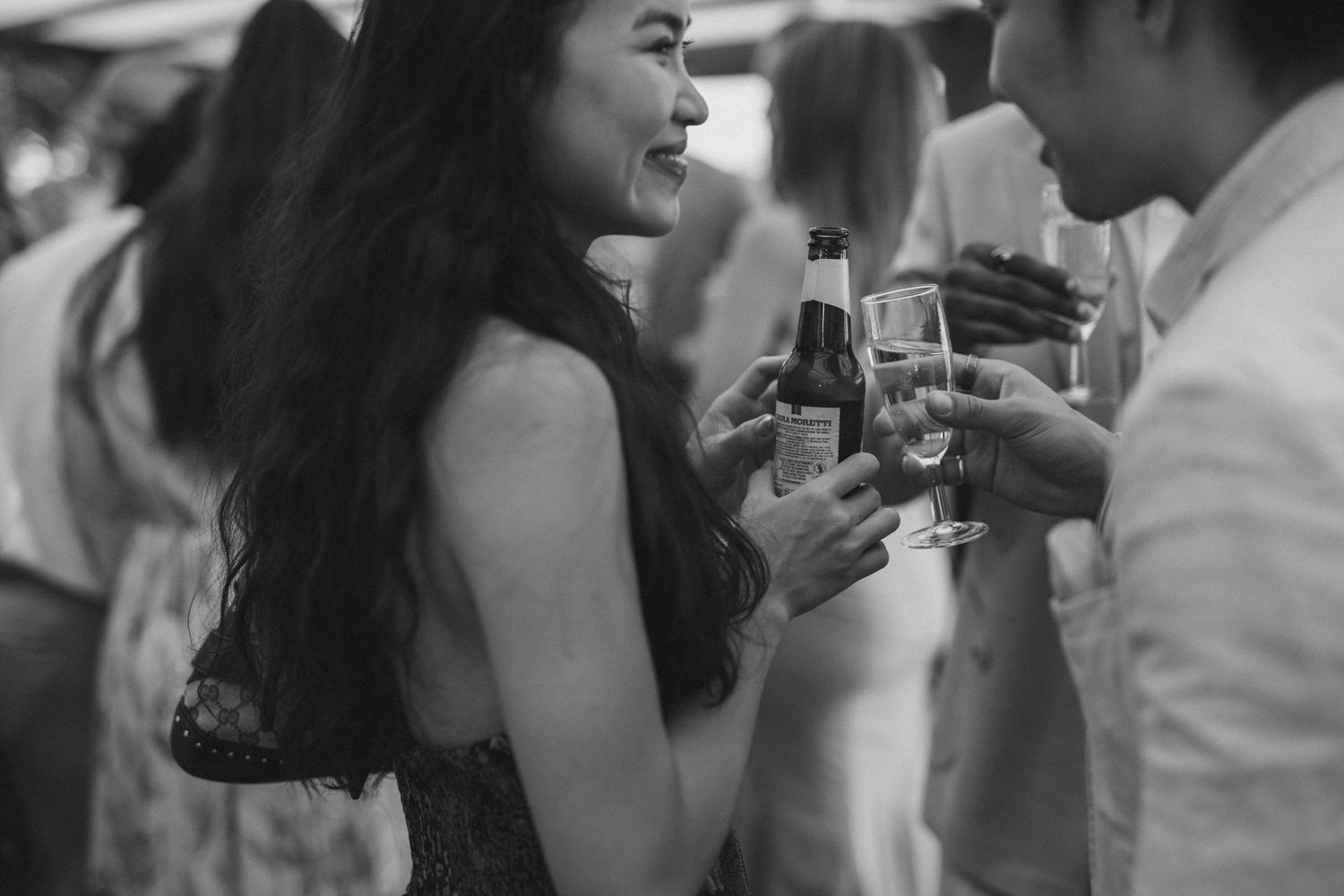 Reception party scene with guests mingling and celebrating in evening lighting.